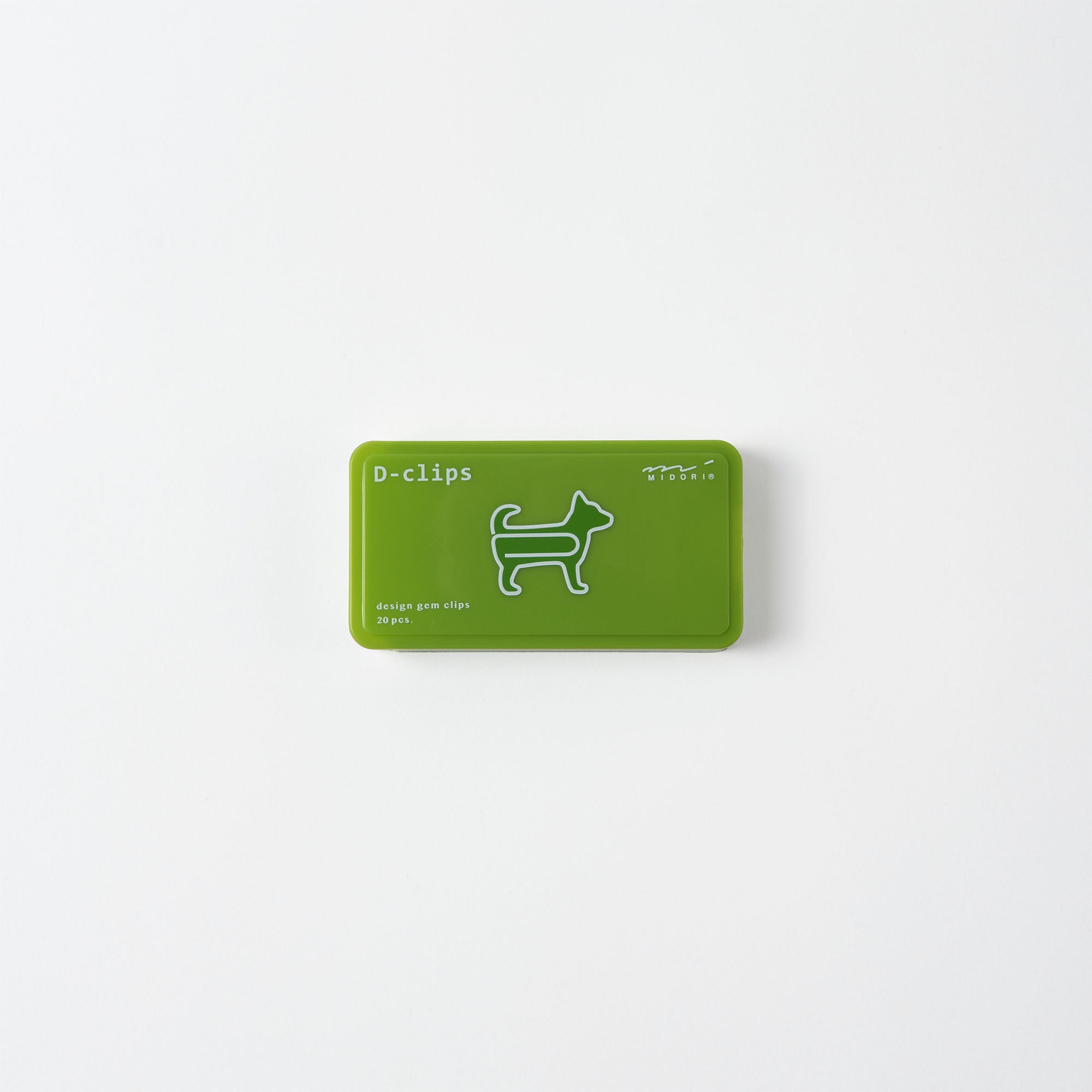Eine kleine grüne rechteckige Schachtel mit der Aufschrift „D-Clips: Büroklammern Hund“ von Midori zeigt die weiße Umrisszeichnung eines Hundes und strahlt eine charmante Note aus. Die minimalistische Verpackung spiegelt japanisches Designgefühl vor einem schlichten weißen Hintergrund wider.