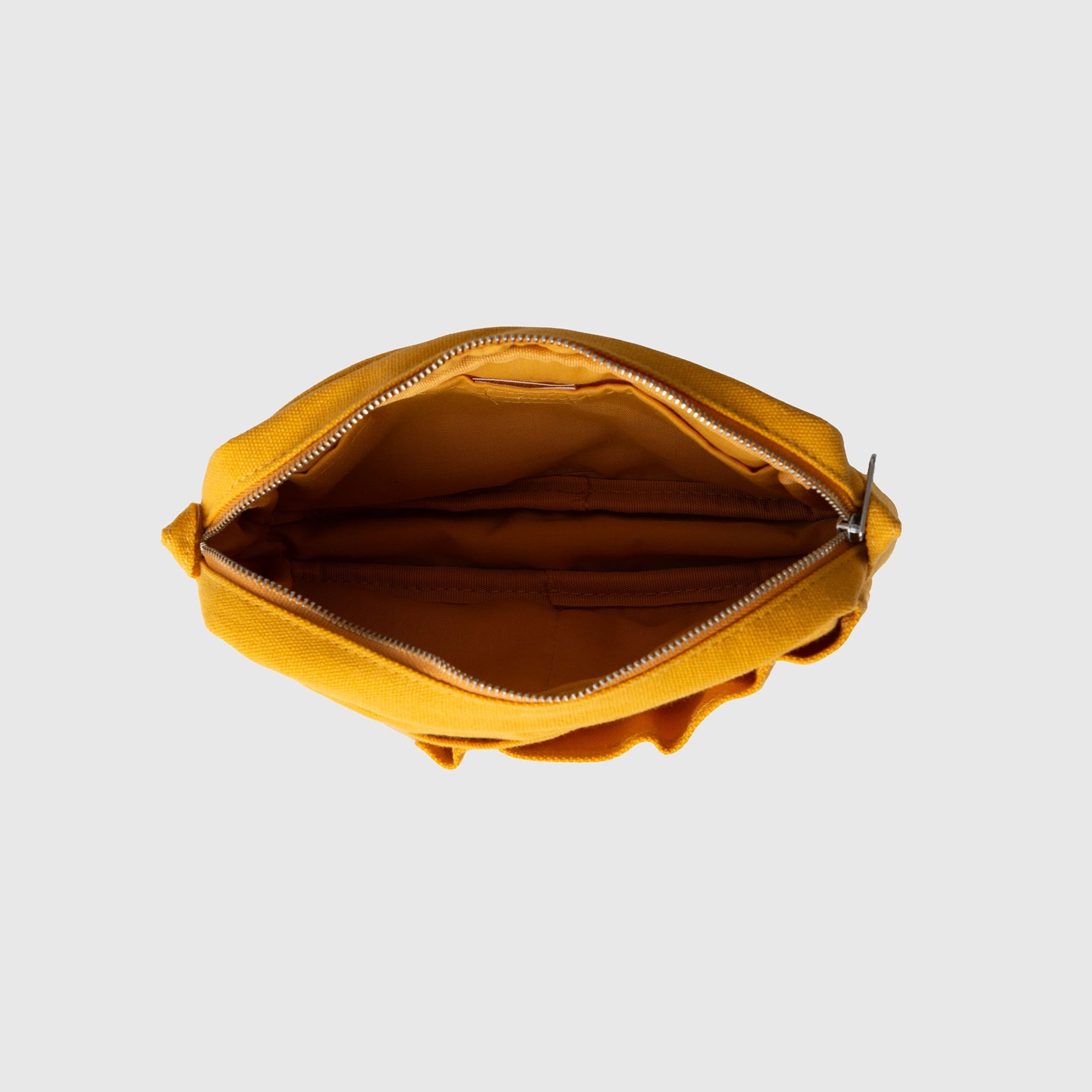 Eine Draufsicht auf einen offenen, gelben Stoffbeutel mit Reißverschluss, den „Delfonics Inner Carrying Bag S“ von Delfonics, mit einem sichtbaren Innenfach vor einem einfarbigen hellgrauen Hintergrund.