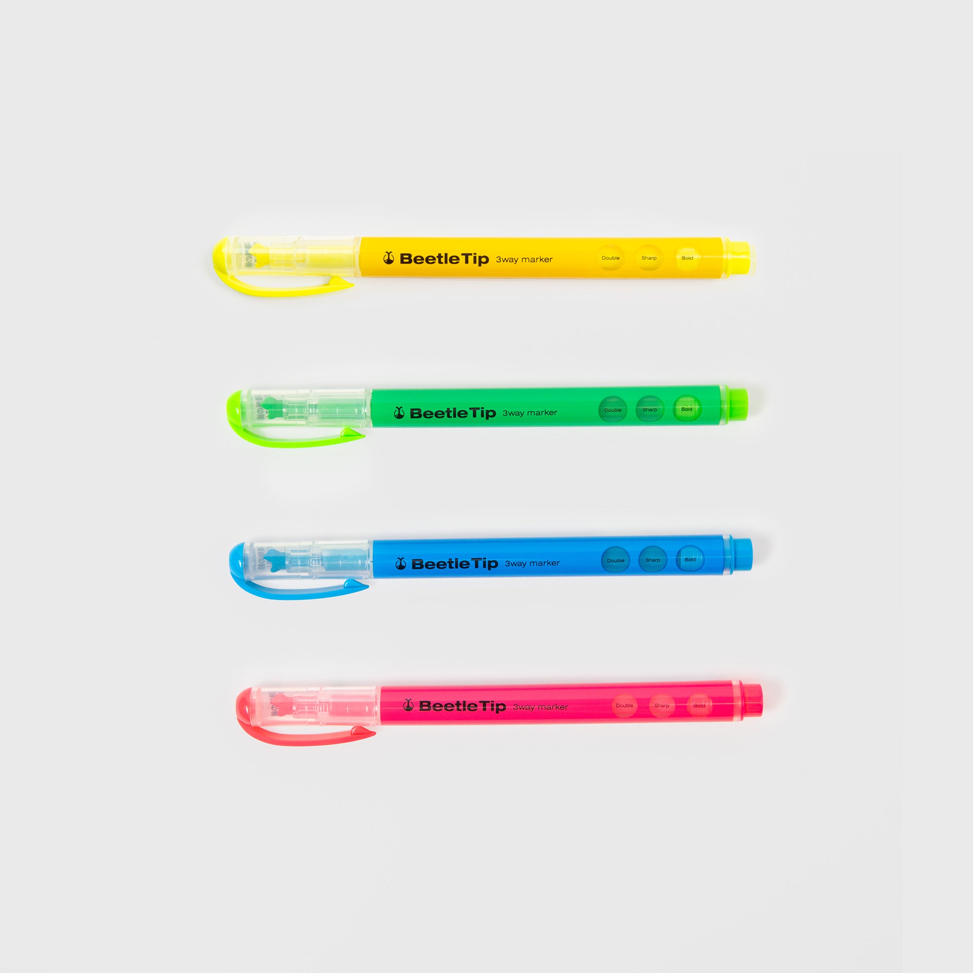 Vier Kokuyo Beetletip 3-Way Highlighter in den Farben Gelb, Grün, Blau und Pink sind horizontal auf einem weißen Hintergrund angeordnet, jeweils mit passenden Kappen auf der linken Seite - ideal zum Hervorheben oder zum Erstellen von drei Linien.