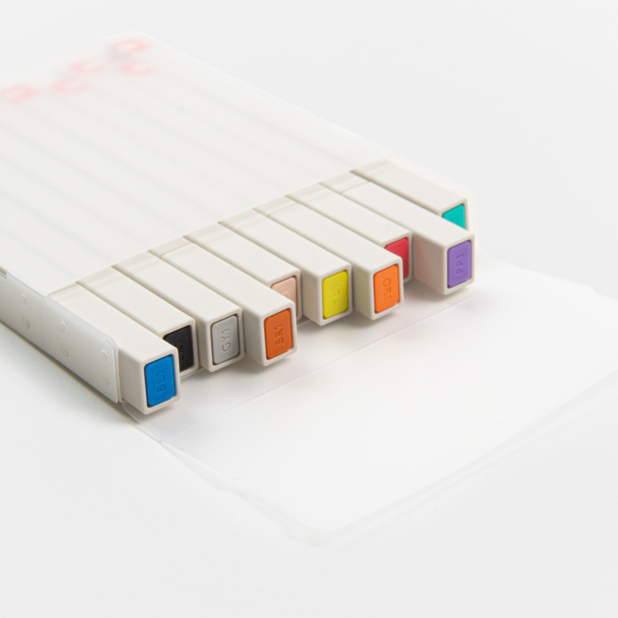 Das Kokuyo Pasta Marker Set 10 Farben enthält zehn farbig beschriftete Marker in einem schlichten weißen Etui. Die Marker sind mit verdeckten Spitzen auf einem minimalistischen weißen Hintergrund angeordnet und eignen sich ideal zum Schreiben von Tagebüchern.