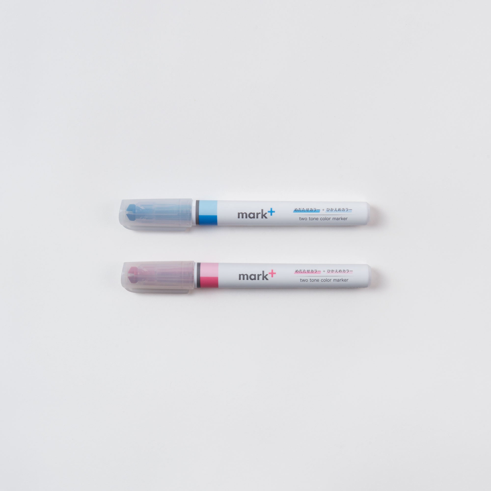 Nebeneinander auf weißem Untergrund stehen zwei Marker von Kokuyo. Der obere, „Ein (Text-) Marker, Zwei Farben“, hat an jedem Ende eine blaue und eine violette Kappe. Darunter befindet sich ein Fineliner-Spitzen-Design mit roter und gelber Kappe. Beide tragen die Aufschrift „mark+ two tone color marker“.