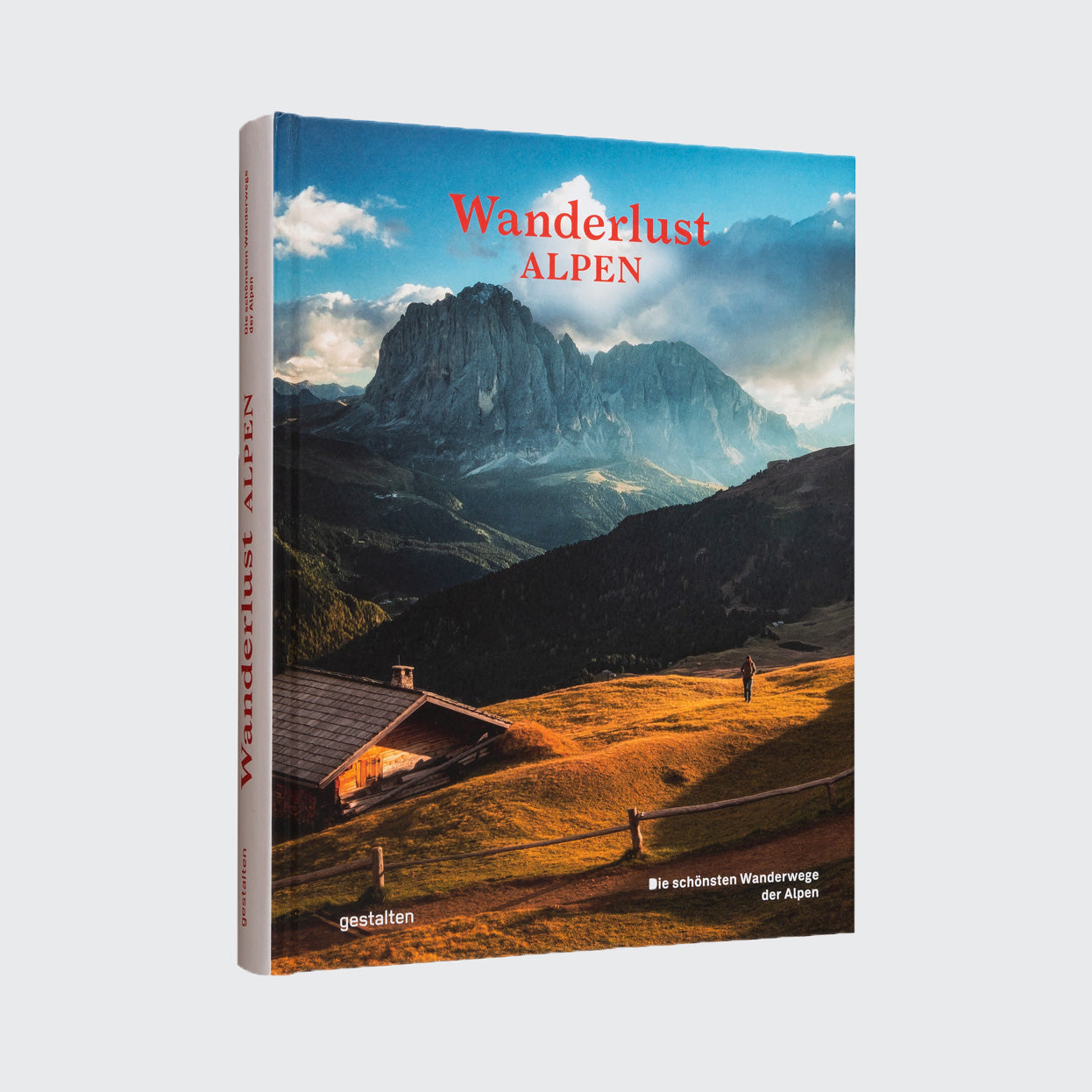 „Wanderlust Alpen“ vom Gestalten Verlag fängt das Fernweh auf wunderschöne Weise mit einem malerischen Cover einer Alpenlandschaft ein, mit einer Holzhütte, sonnenbeschienenen Grashügeln und einem klaren blauen Himmel, und lädt die Leser ein, die magischen Wanderwege der Alpen zu erkunden.