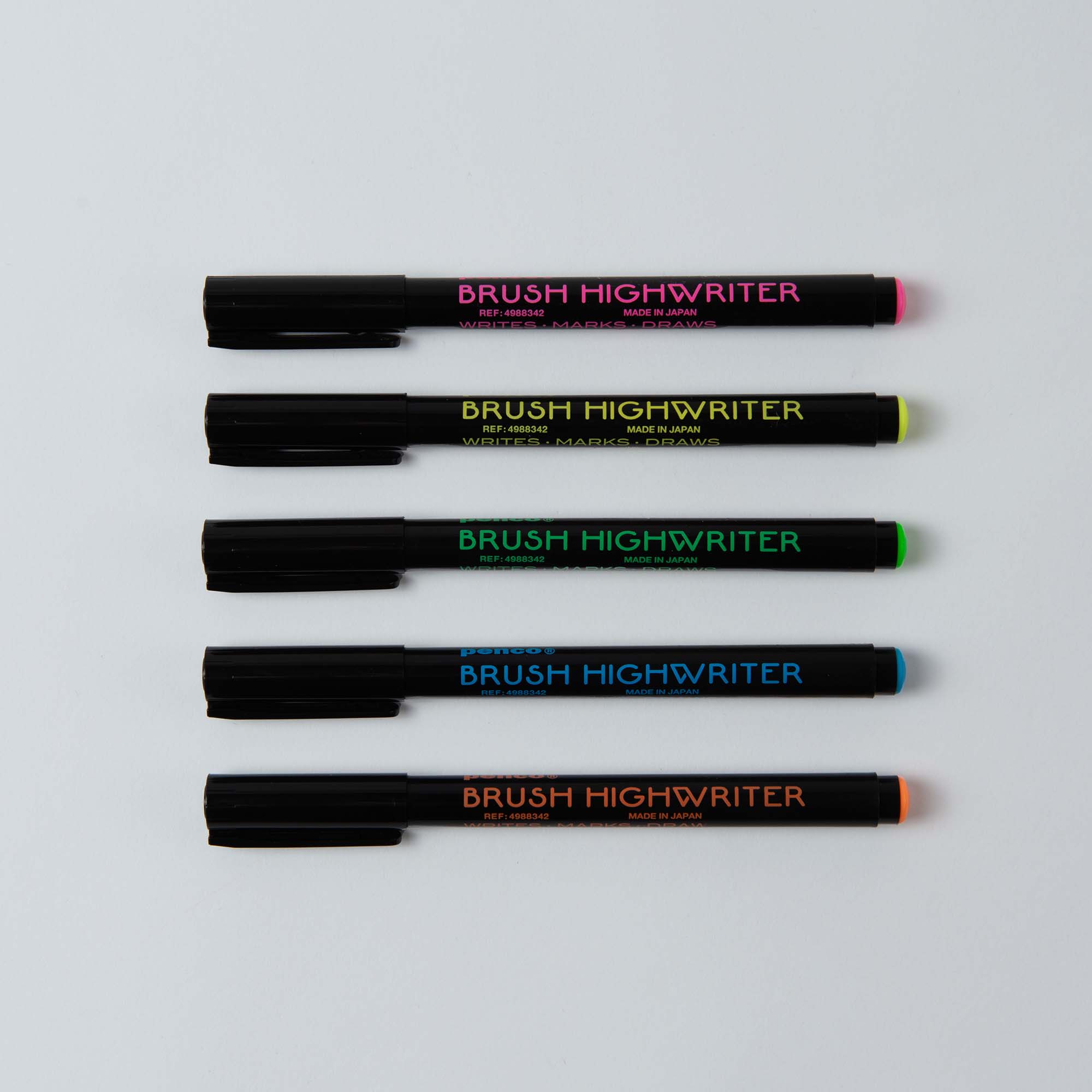 Fünf Penco Brush Highwriter mit schwarzem Schaft, leuchtenden Pinselspitzen und rosa, grünen, gelben, blauen und orangefarbenen Etiketten sind horizontal auf einem hellen Hintergrund angeordnet.