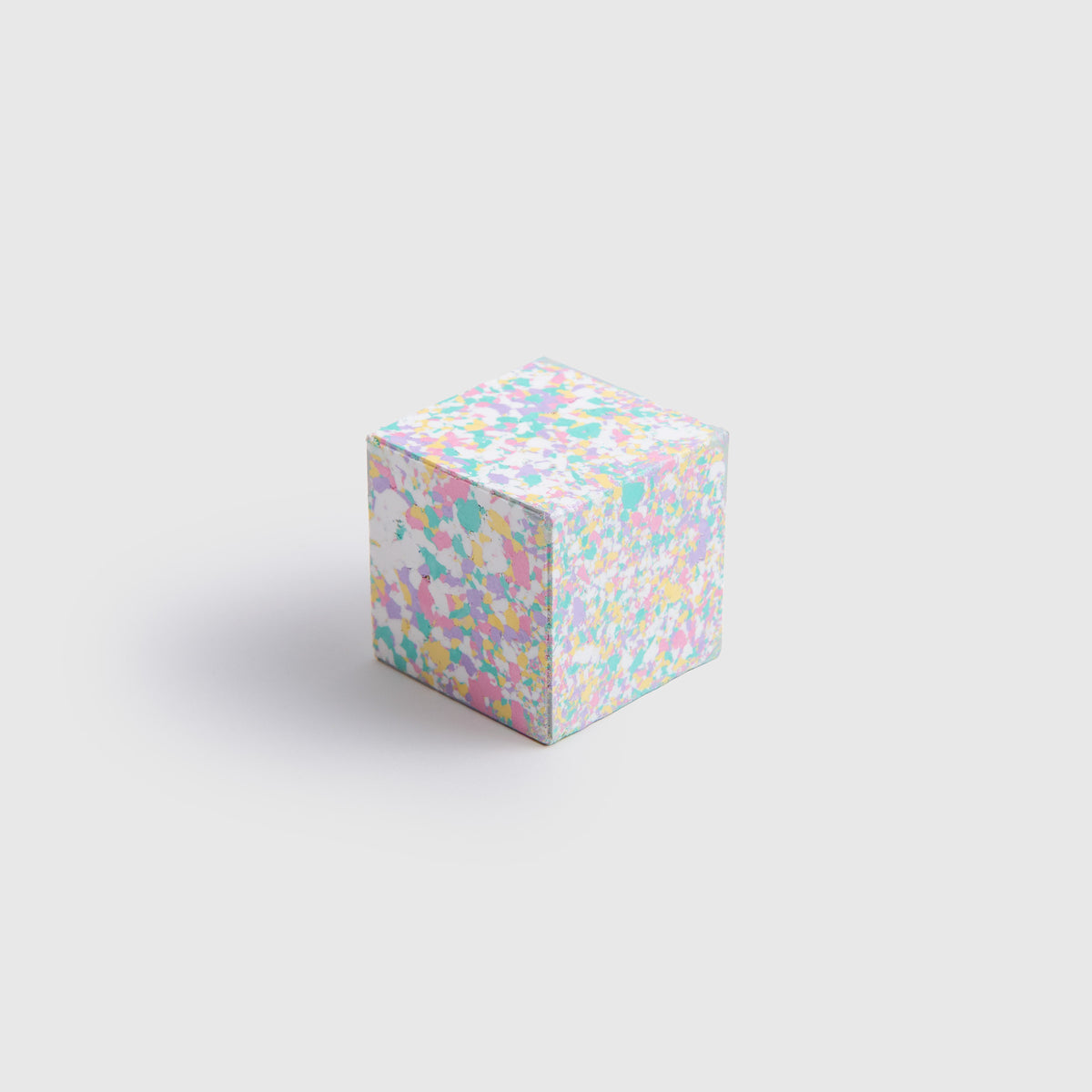 Ein kleiner Würfel aus der „Color Gem“-Reihe von Studio Unto – das Wachsmalquadrat – Einzelpackung – liegt auf einer weißen Fläche; seine Seiten sind mit leuchtenden pastellfarbenen Konfetti-Sprenkeln in Rosa, Gelb, Blau, Violett und Grün verziert – was an die lebendige „Color Gem“-Farbpalette erinnert, die häufig in künstlerischen Kreationen zum Einsatz kommt.