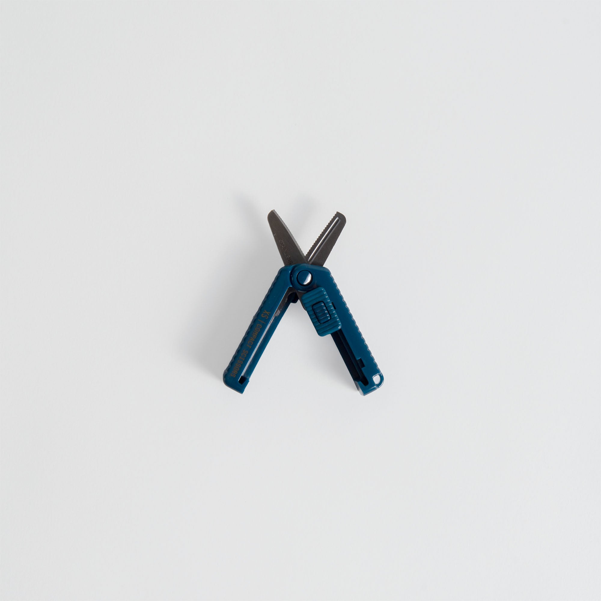 Ein kompaktes blaues Midori Compact Scissors Cerrated Multitool mit ausgefahrener Schere, fotografiert auf einem schlichten weißen Hintergrund.