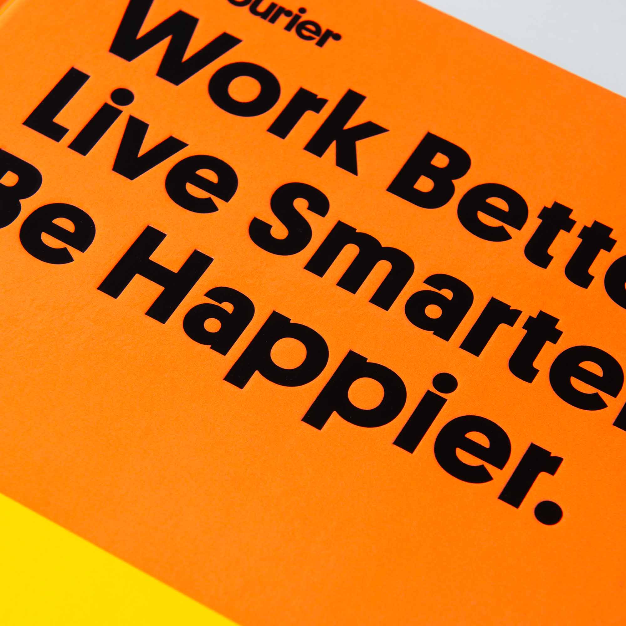 Die Nahaufnahme eines orangefarbenen Buchcovers verkündet unmissverständlich: „Arbeite besser. Lebe intelligenter. Sei glücklicher.“ Oben deutet „Gestalten Verlag“ auf eine Reise zu einem besseren Leben und mehr Freude hin, indem man ein Unternehmen gründet und sich ein Leben aufbaut, das man liebt.