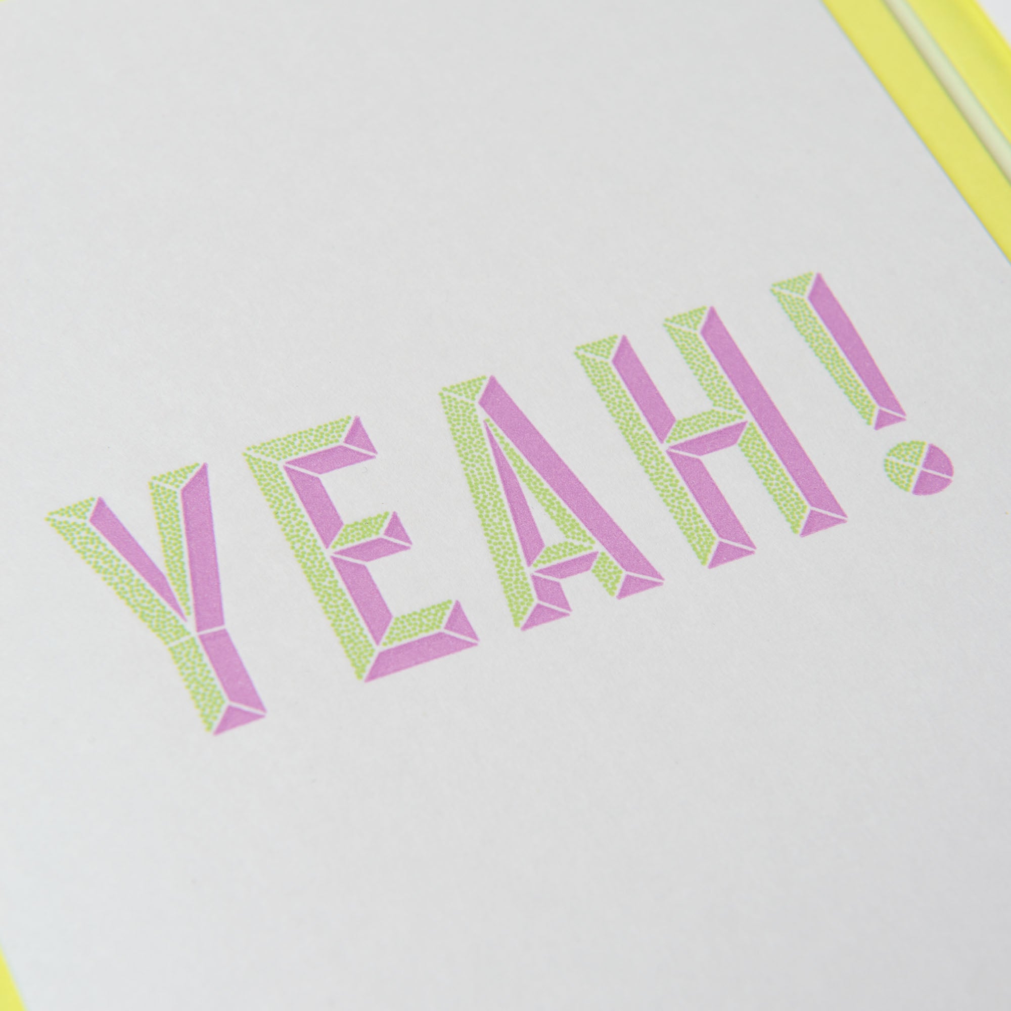 Das Bild zeigt „YEAH!“ in stilisierten violetten und grünen geometrischen Buchstaben auf hellem Hintergrund und spiegelt so das moderne Gmund-Buchdruck-Flair des Grußkartensets YEAH & Konfetti von paperlux.store wider.