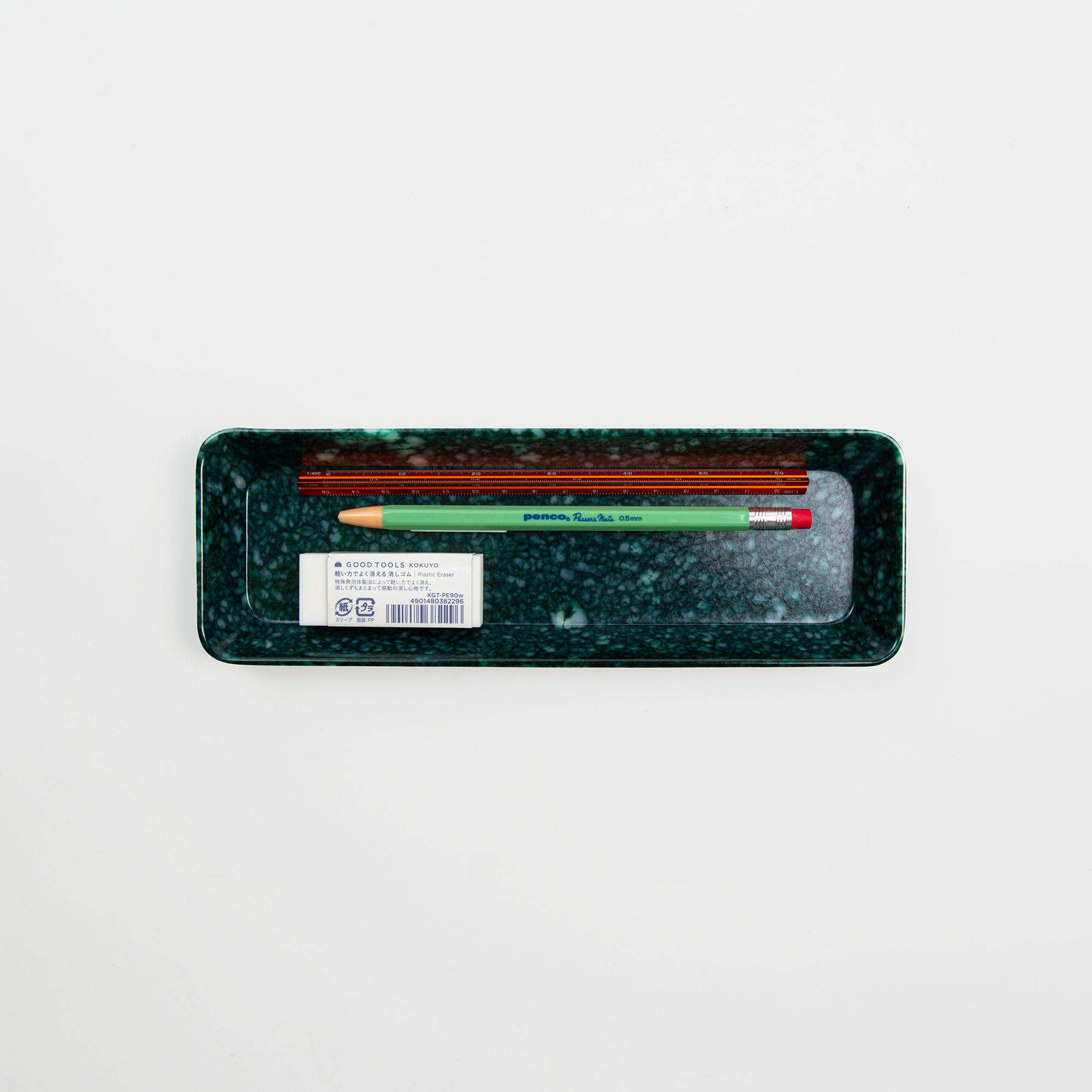 Das Pen Tray Dark Green von Hightide fasst einen braunen Stift und einen grünen Bleistift mit Radiergummi auf weißem Hintergrund. Eine stilvolle Art, Ihre Schreibwaren zu organisieren.