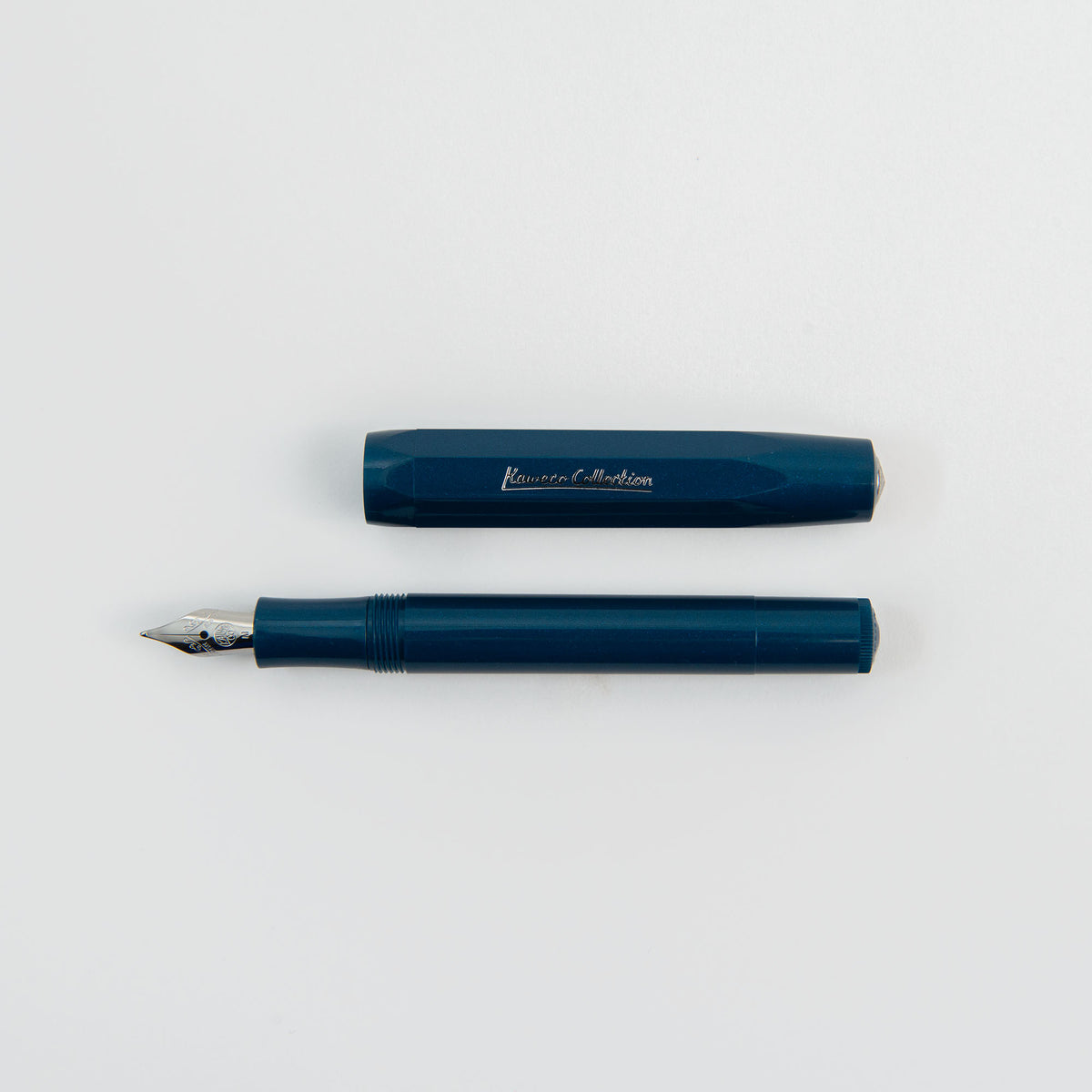 Ein blauer Kaweco Classic Sport – Füllhalter von Kaweco, dessen Kappe abgenommen und über dem Schaft platziert ist; beide liegen auf einem weißen Hintergrund. Auf der Kappe ist der Schriftzug „Kaweco Collection“ zu sehen, während die goldene Feder diesem kompakten Füllhalter eine elegante Note verleiht.