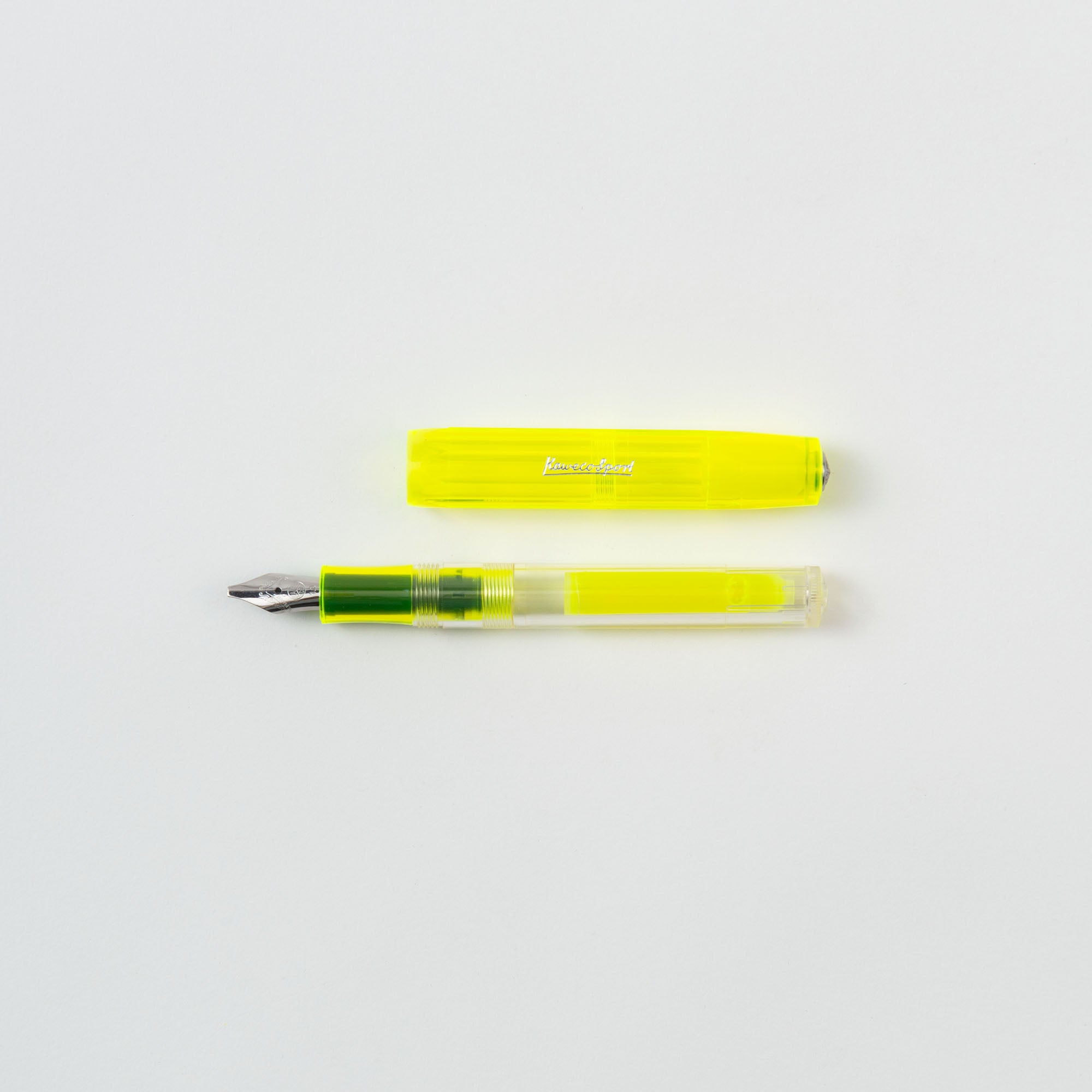 Das Kaweco Highlighter Set Neongelb enthält einen transparenten gelben Stift, der einem Textmarker ähnelt. Wenn die Kappe abgenommen und darübergelegt wird, gibt der teilweise durchsichtige Schaft den Blick auf das Tintenreservoir frei. Eine metallisch silberne Feder kontrastiert mit einem soliden weißen Hintergrund, perfekt für eifrige Lerner.