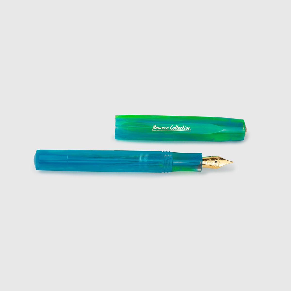 Ein blau-grüner Füllfederhalter der Kaweco Collection – „Marble Ocean“ – mit goldener Feder liegt neben seiner passenden Kappe, die mit der Aufschrift „Kaweco Collection“ versehen ist, auf einem schlichten, hellen Hintergrund. Dieses elegante Schreibgerät ist Teil der exklusiven limitierten Kaweco Sport-Edition.