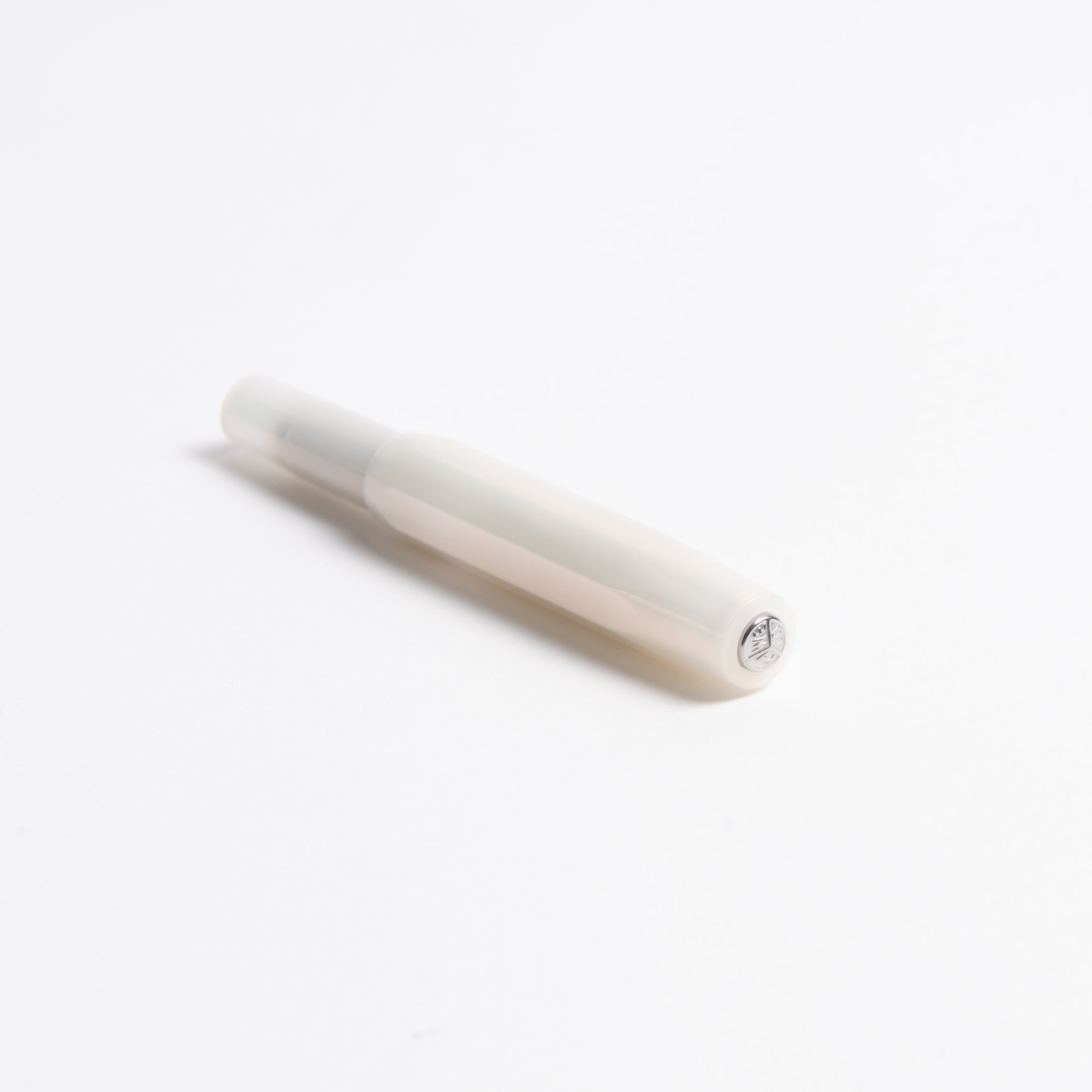 Ein Kaweco Lunar Sport - Füllhalter aus weißem ABS-Kunststoff mit hexagonalem Barrel liegt diagonal auf weißem Hintergrund, die austauschbare Federeinheit und der Deckel zeigen nach vorne.