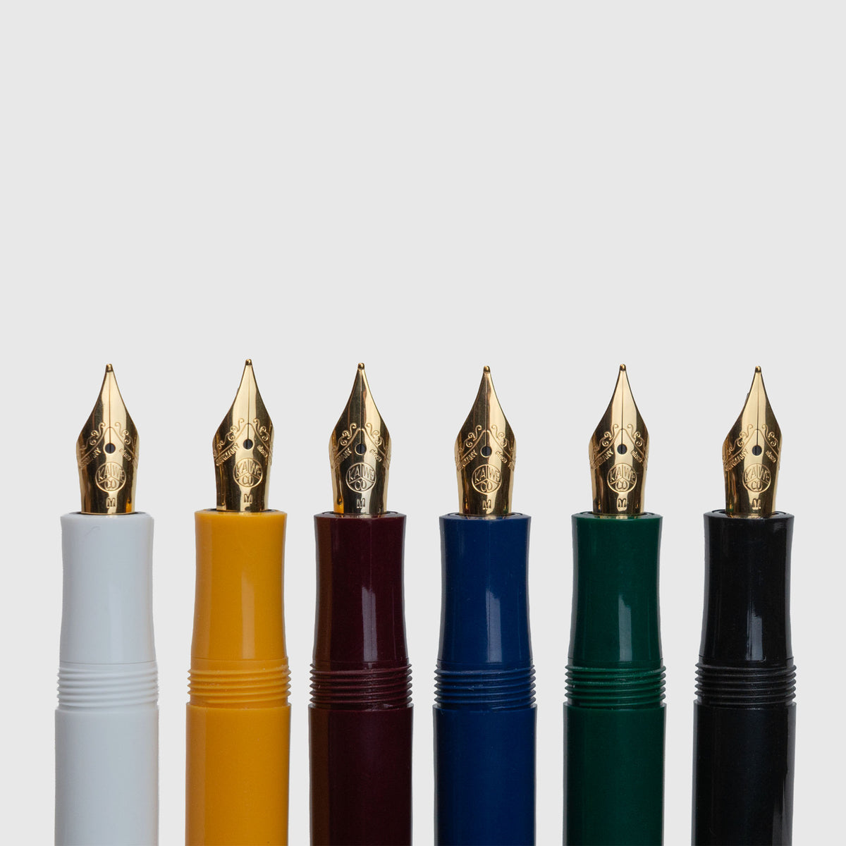 Sechs Kaweco Classic Sport – Füllhalter von Kaweco, jeweils mit einer goldenen Feder und Schaft in den Farben Weiß, Gelb, Burgunderrot, Blau, Grün und Schwarz, sind vertikal vor einem schlichten hellgrauen Hintergrund angeordnet – eine Präsentation, die an das ikonische Design der beliebten Sport-Serie anknüpft.