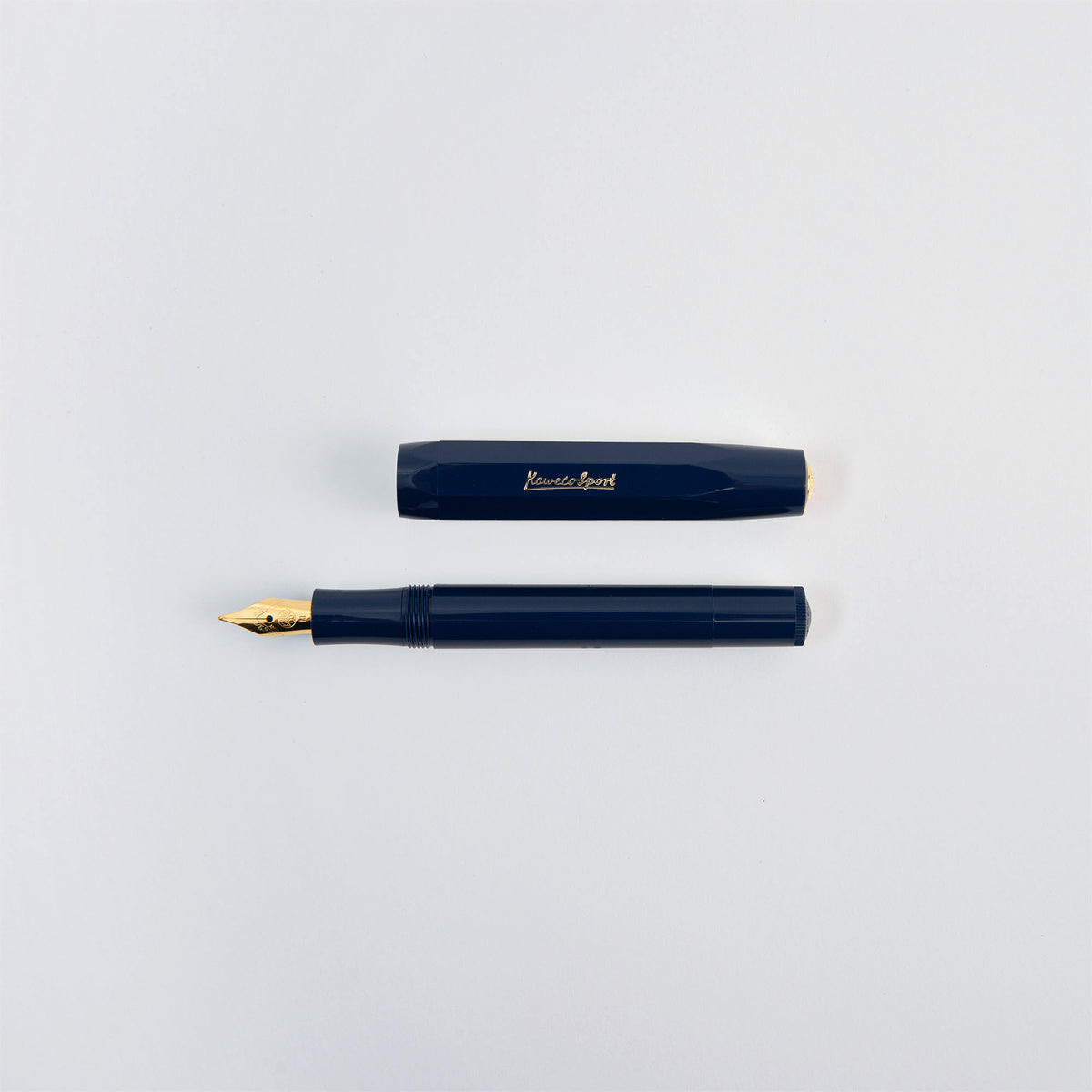 Ein marineblauer Kaweco Classic Sport – Füllhalter, abgebildet mit abgenommener Kappe, die neben dem Schaft liegt.