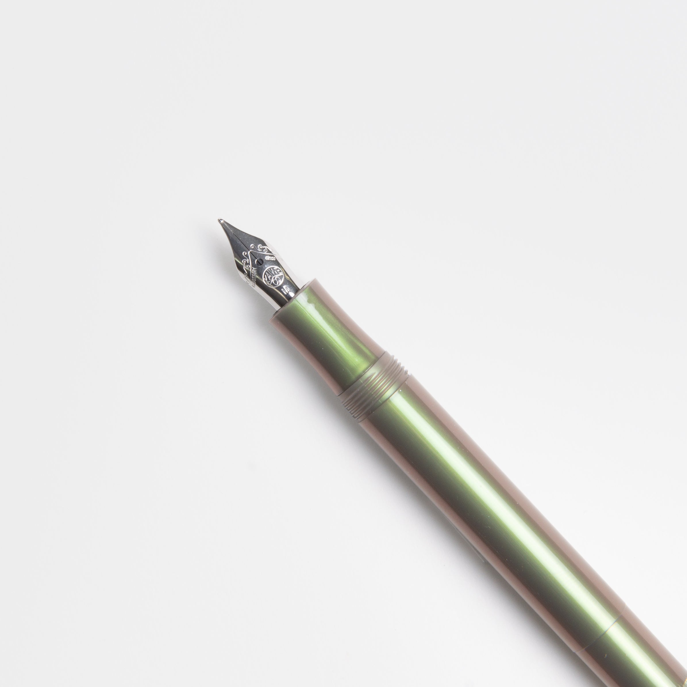 Ein Kaweco Lunar Sport - Füllhalter in metallisch grünem ABS-Kunststoff mit silberner Feder und austauschbarer Federeinheit liegt diagonal auf einem schlichten weißen Hintergrund.