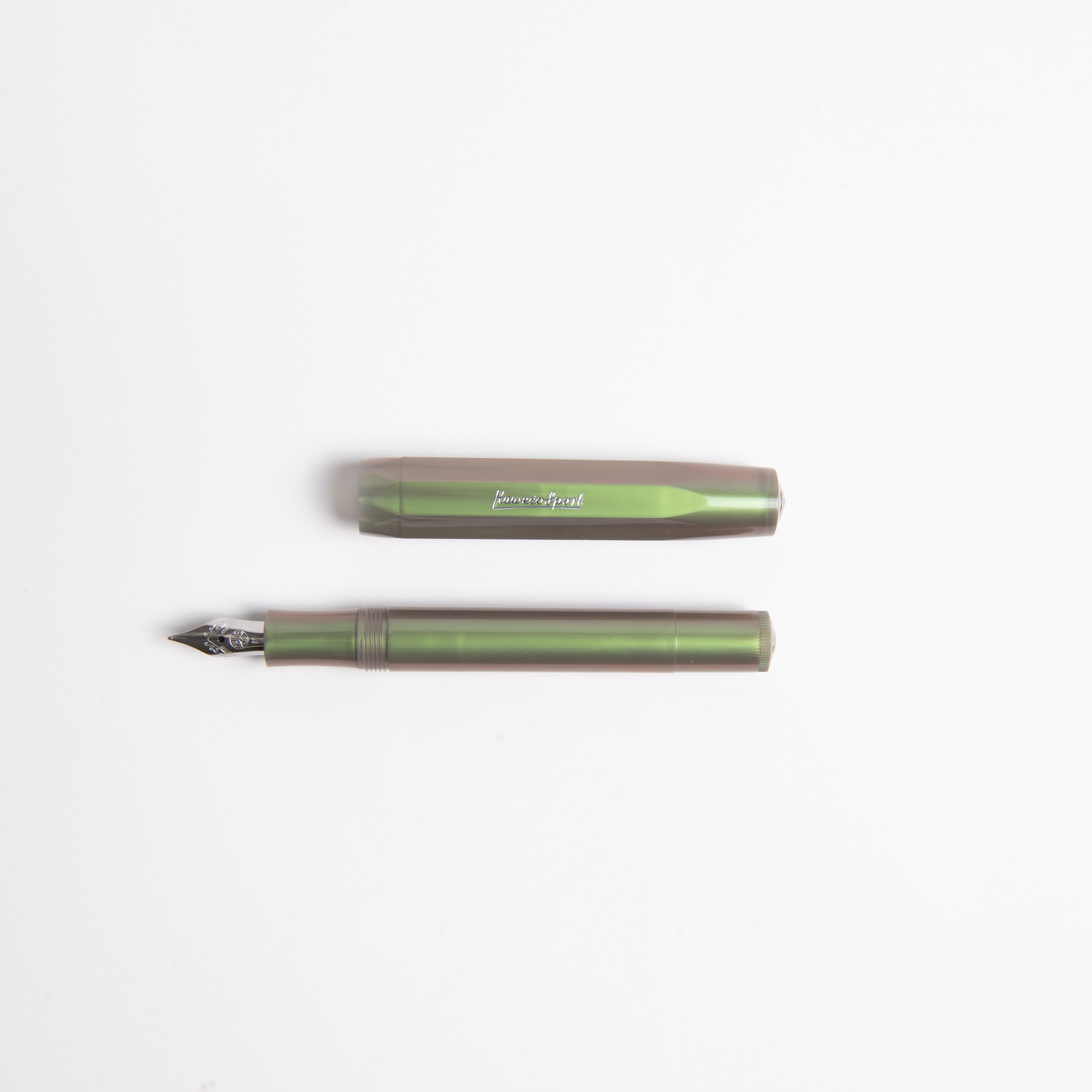 Ein Kaweco Lunar Sport - Füllhalter in Grün aus robustem ABS-Kunststoff liegt mit abgenommener Kappe horizontal auf weißem Hintergrund.
