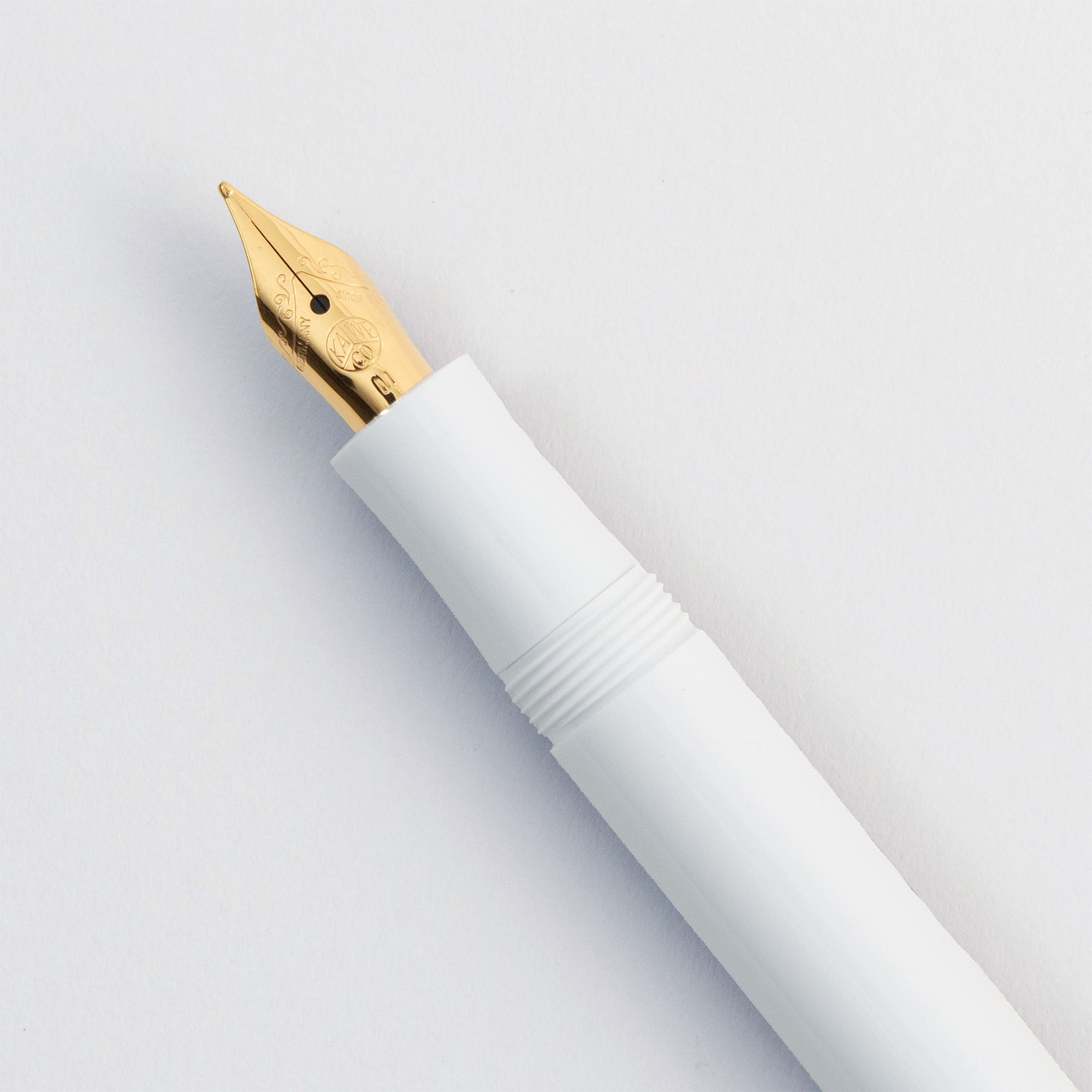 Eine Nahaufnahme des Kaweco Füllhalter Gold Akzent von Kaweco mit einer Goldfeder, die diagonal auf einem schlichten weißen Hintergrund steht.