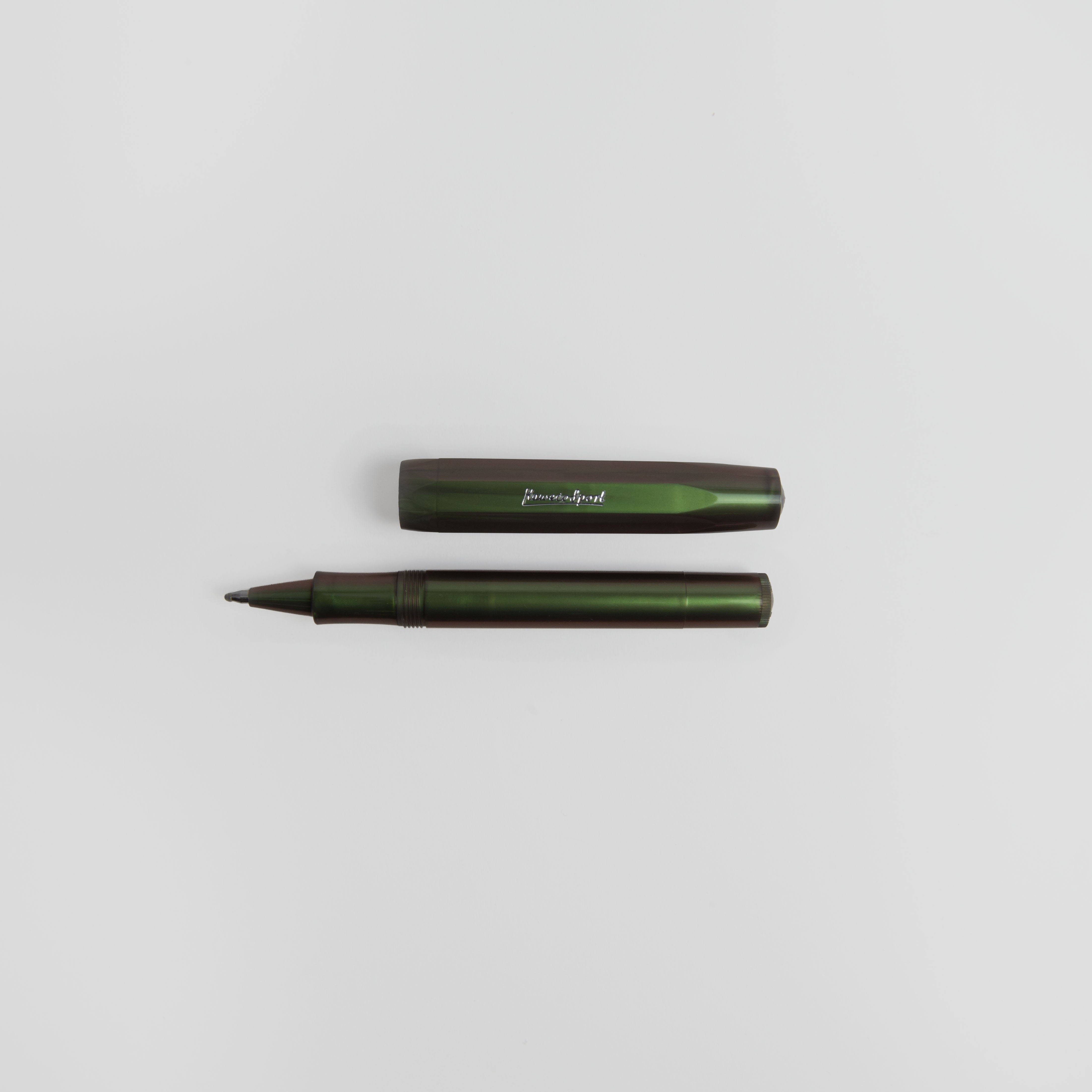 Ein Kaweco Lunar Sport - Kugelschreiber von Kaweco, abgebildet ohne Kappe auf einem schlichten weißen Hintergrund. Der dunkelgrüne Schaft und die Kappe mit dezentem Perlglanz-Effekt sind waagerecht angeordnet, wobei die Kappe oberhalb des Stiftes liegt.