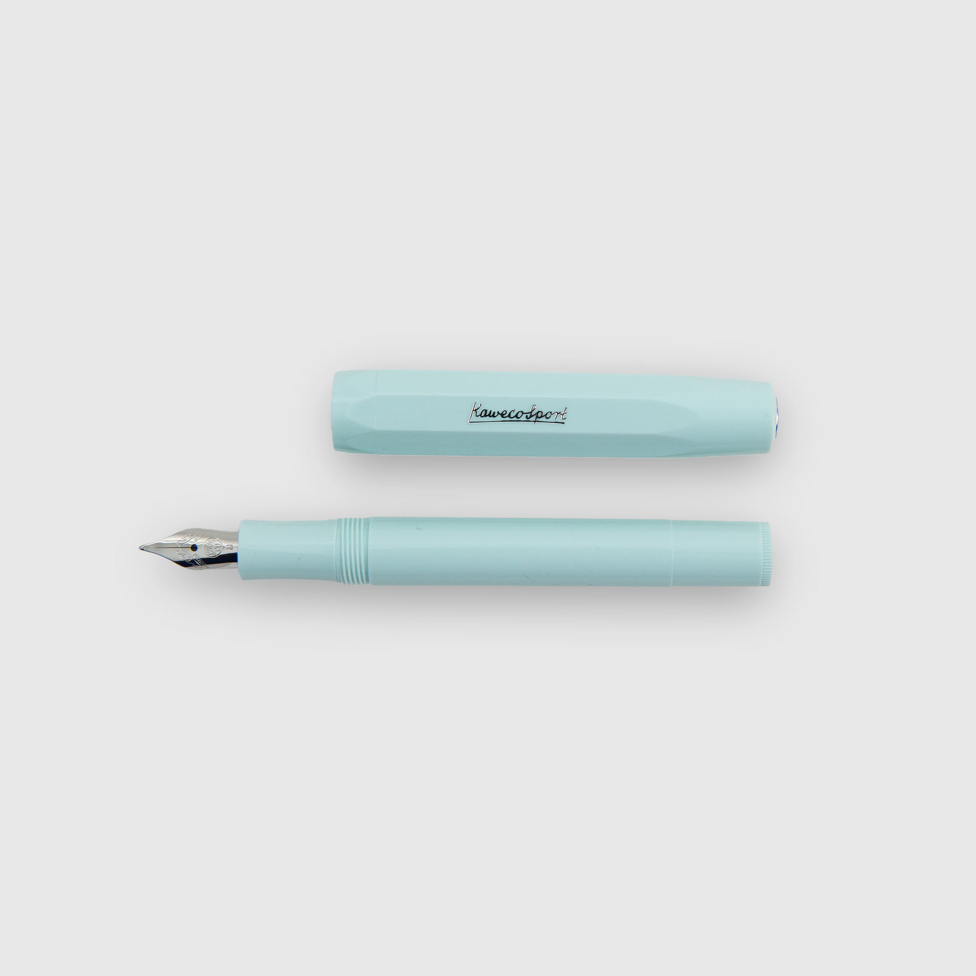 Ein Kaweco Skyline Sport - Füllhalter in hellblau mit silberner Feder wird neben der passenden "Kaweco Sport" Kappe auf einem schlichten weißen Hintergrund präsentiert.