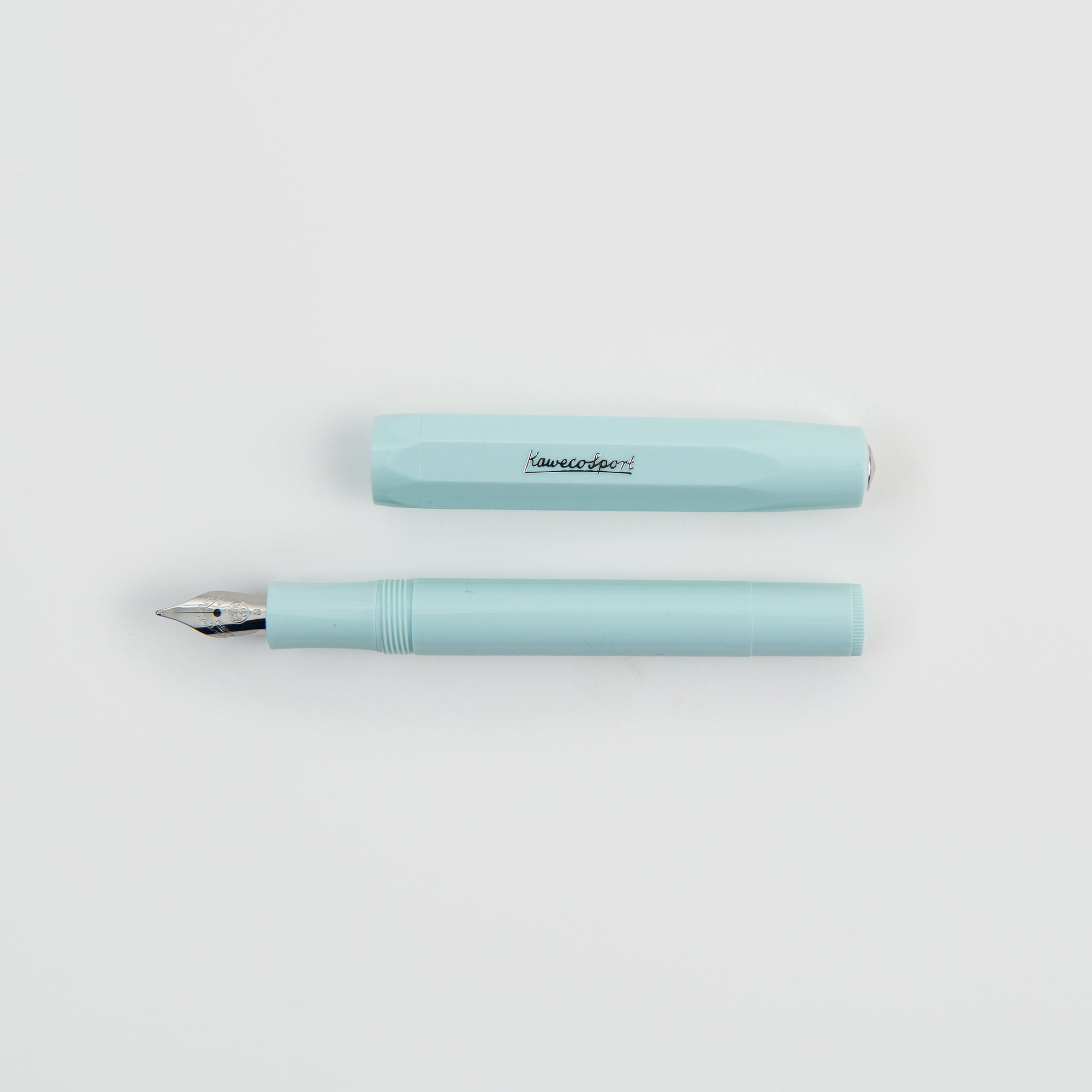 Ein Kaweco Füllhalter - mit silbernem Akzent, mit silberner Feder, liegt ohne Kappe auf einem schlichten weißen Hintergrund. Die Kappe ist elegant mit dem ikonischen Logo beschriftet.