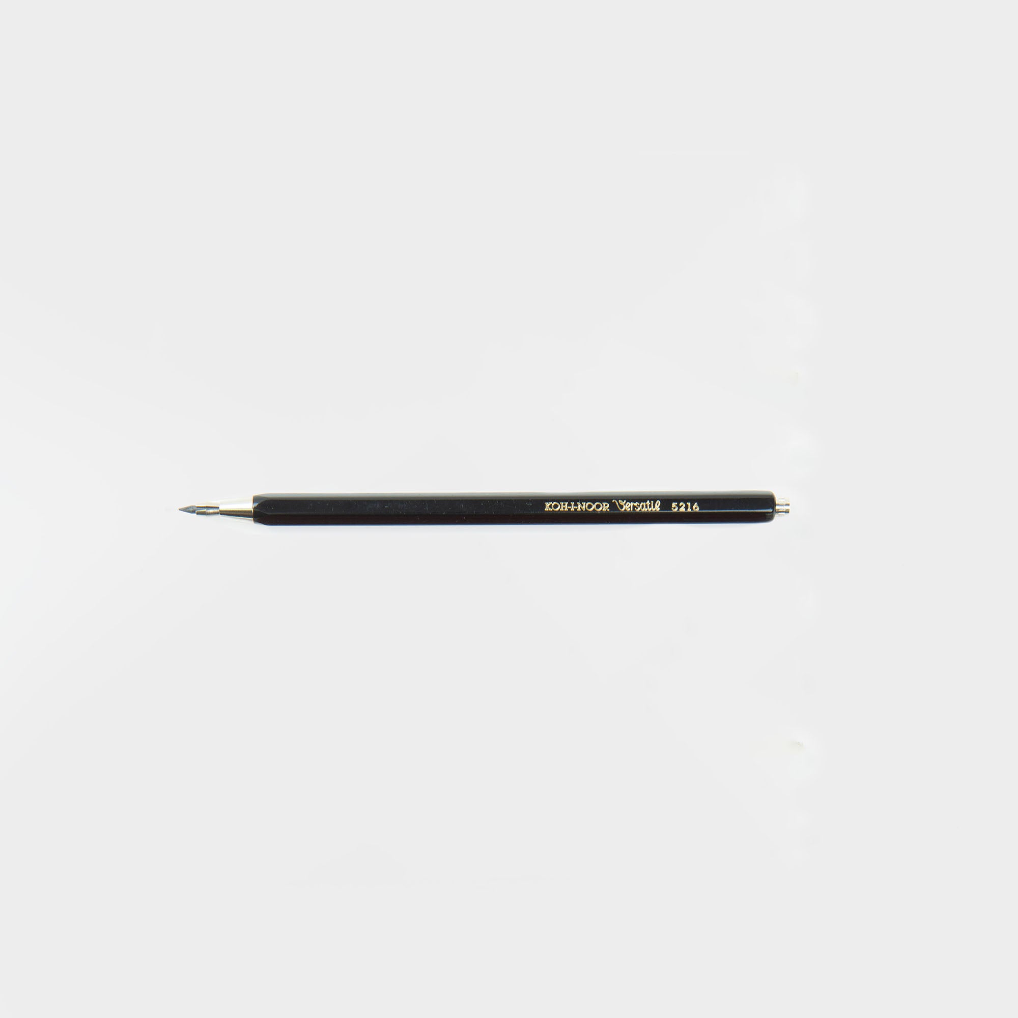Eine Koh-i-noor Druckbleistift Versatil-Mine mit metallischer Spitze und Ende liegt waagerecht auf weißem Grund. Im Gegensatz zu einem Bleistift hat er gelbe und weiße Schrift auf seiner Seite und kommt in einem Set von 10 Farben für Ihre Lieblingsfarbe.