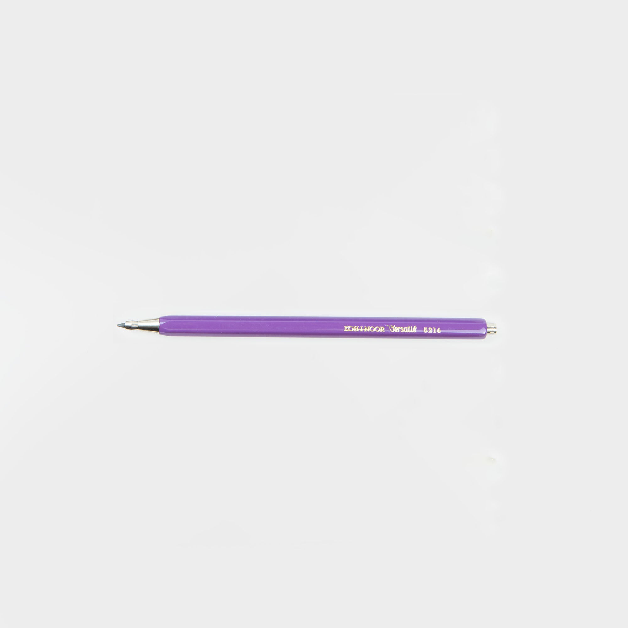 Ein lilafarbener Koh-i-noor Druckbleistift Versatil mit silberner Spitze und weißem Druckknopf liegt waagerecht auf einem schlichten weißen Hintergrund - ideal, wenn Sie statt eines klassischen Bleistifts lieber Lila aus den 10 Farben verwenden.