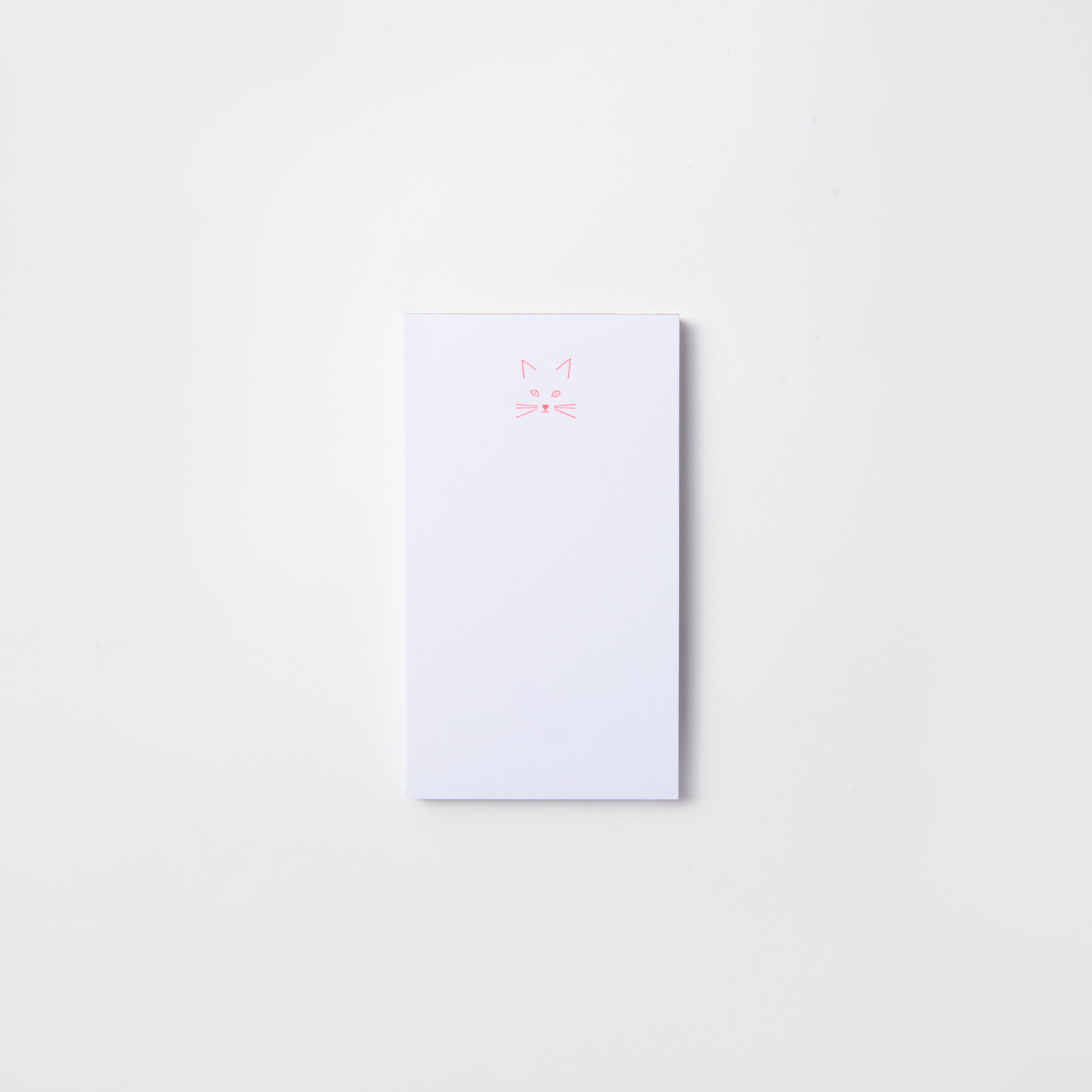 Die Mini-Notizblöcke von Le Typographe - Kiss Kiss, Love Love sind auf weißem Hintergrund mit einem schlichten rosa Katzengesicht abgebildet - ideal für süße Nachrichten oder tägliche Notizen.