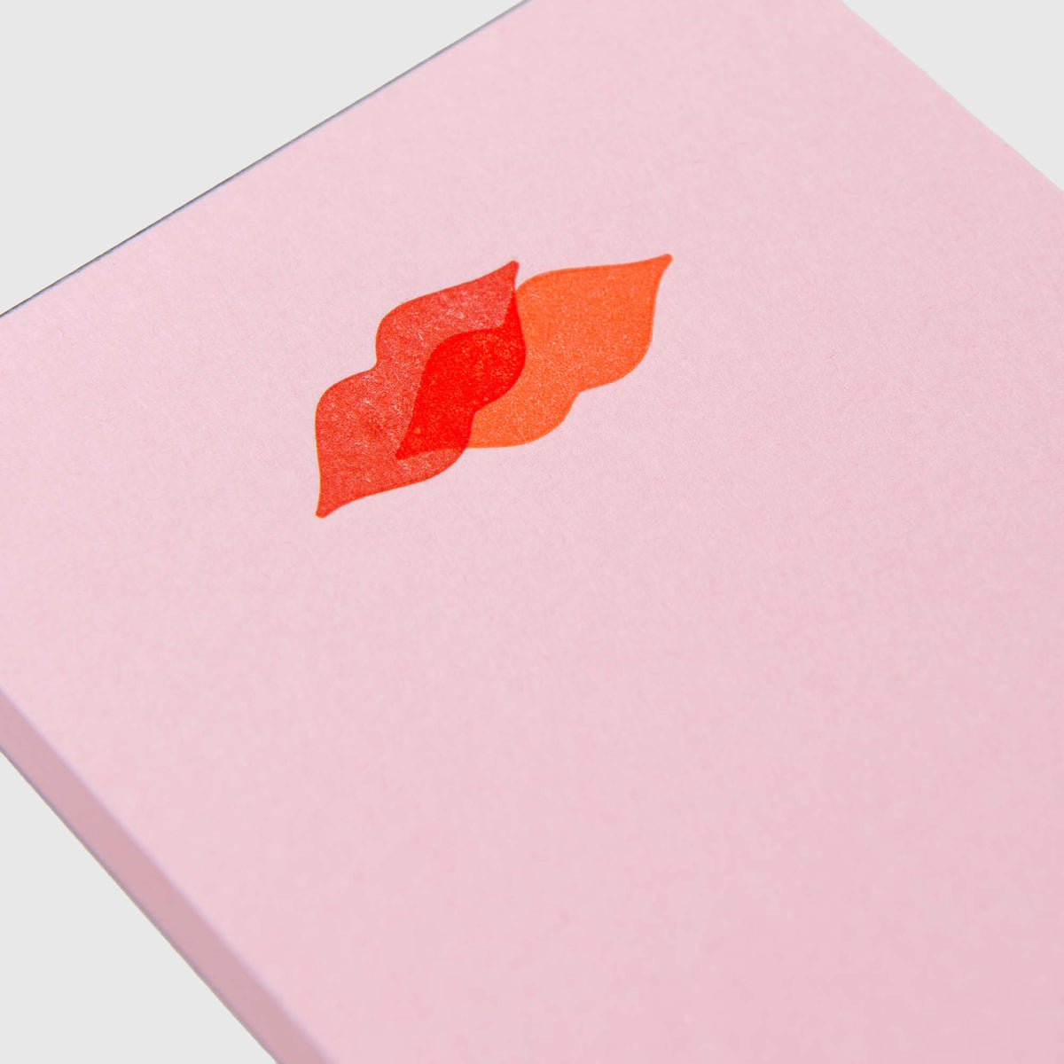 Helle rosa Mini-Notizblöcke – Kiss Kiss, Love Love mit zwei sich überlappenden roten und orangefarbenen Symbolen in Lippenform.