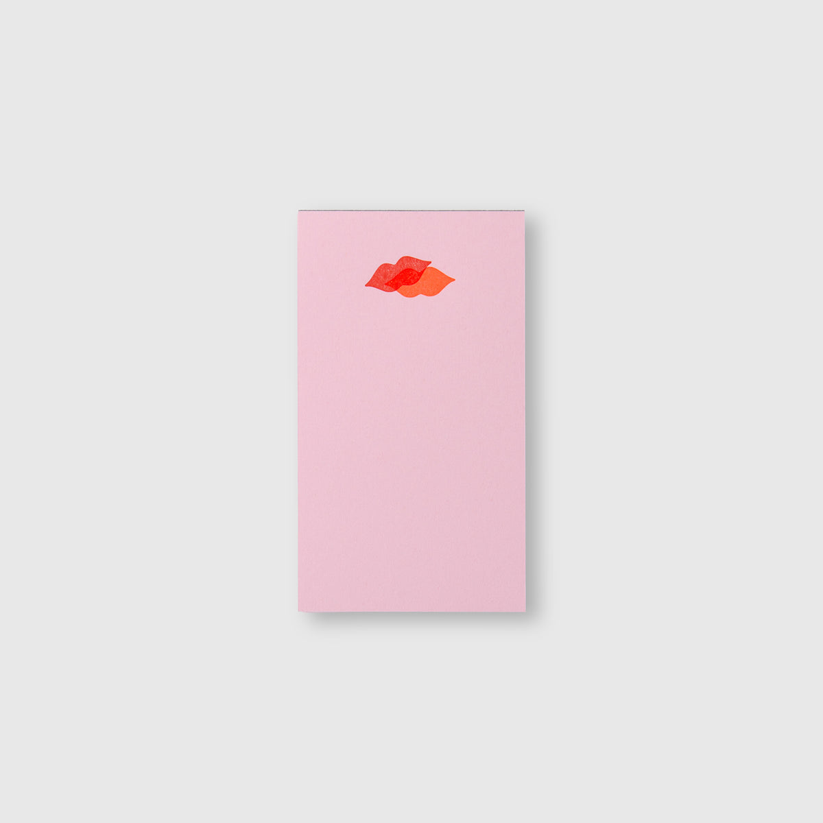Ein rechteckiges, hellrosa Mini-Notizblock – Kiss Kiss, Love Love – mit zwei sich überlappenden roten und orangefarbenen Lippensymbolen am oberen Rand.