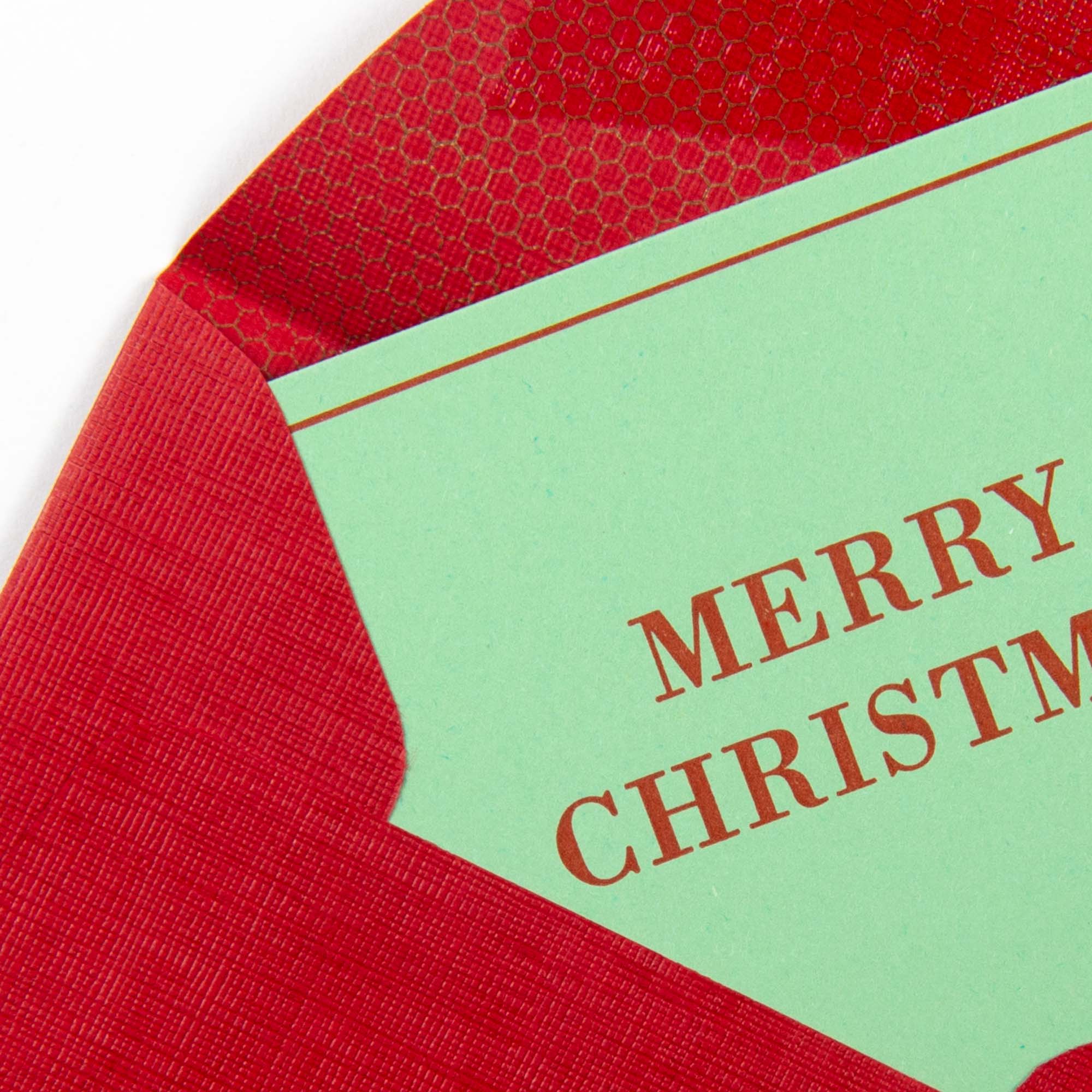 Die Mini Karte "Merry Christmas" von Le Typographe ist eine minimalistische Weihnachtskarte mit grünem Karton, rotem Letterpress-Schriftzug und teilweise strukturiertem roten Umschlag.