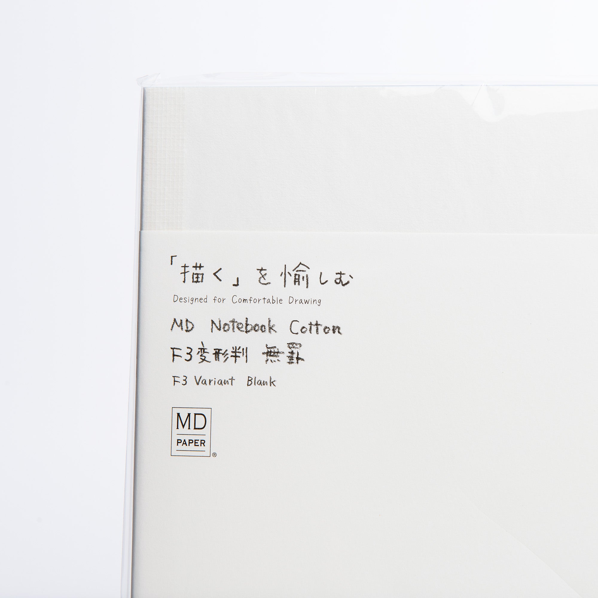 Nahaufnahme eines Notizhefts mit Format von Midori mit japanischem und englischem Text: „Entwickelt für bequemes Zeichnen, MD Notebook Cotton F3 Variant Blank.“ Das MD Paper-Logo unten links unterstreicht die exquisite Fadenbindung und die Qualität des MD Cotton Feinstpapiers.