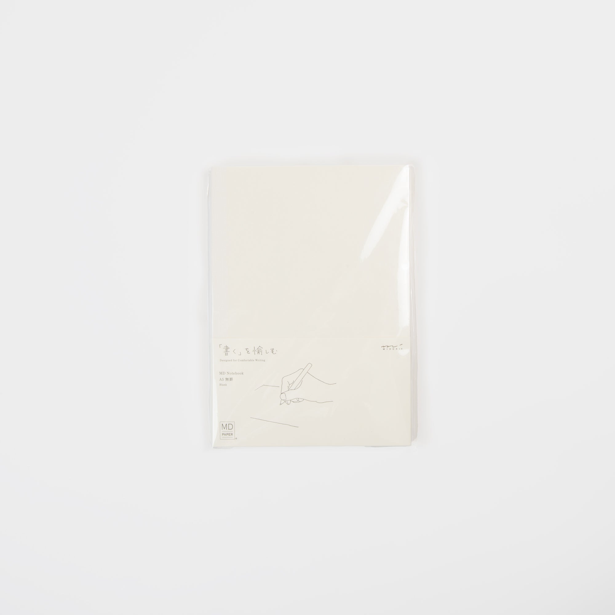 Das Midori MD Notebook A5 besteht aus glattem MD-Papier, einer haltbaren Fadenbindung und einem minimalistischen weißen Einband mit der Strichzeichnung einer Hand, die einen Stift hält. Es wird in einer durchsichtigen Kunststoffverpackung geliefert und ist vor einem schlichten weißen Hintergrund abgebildet.