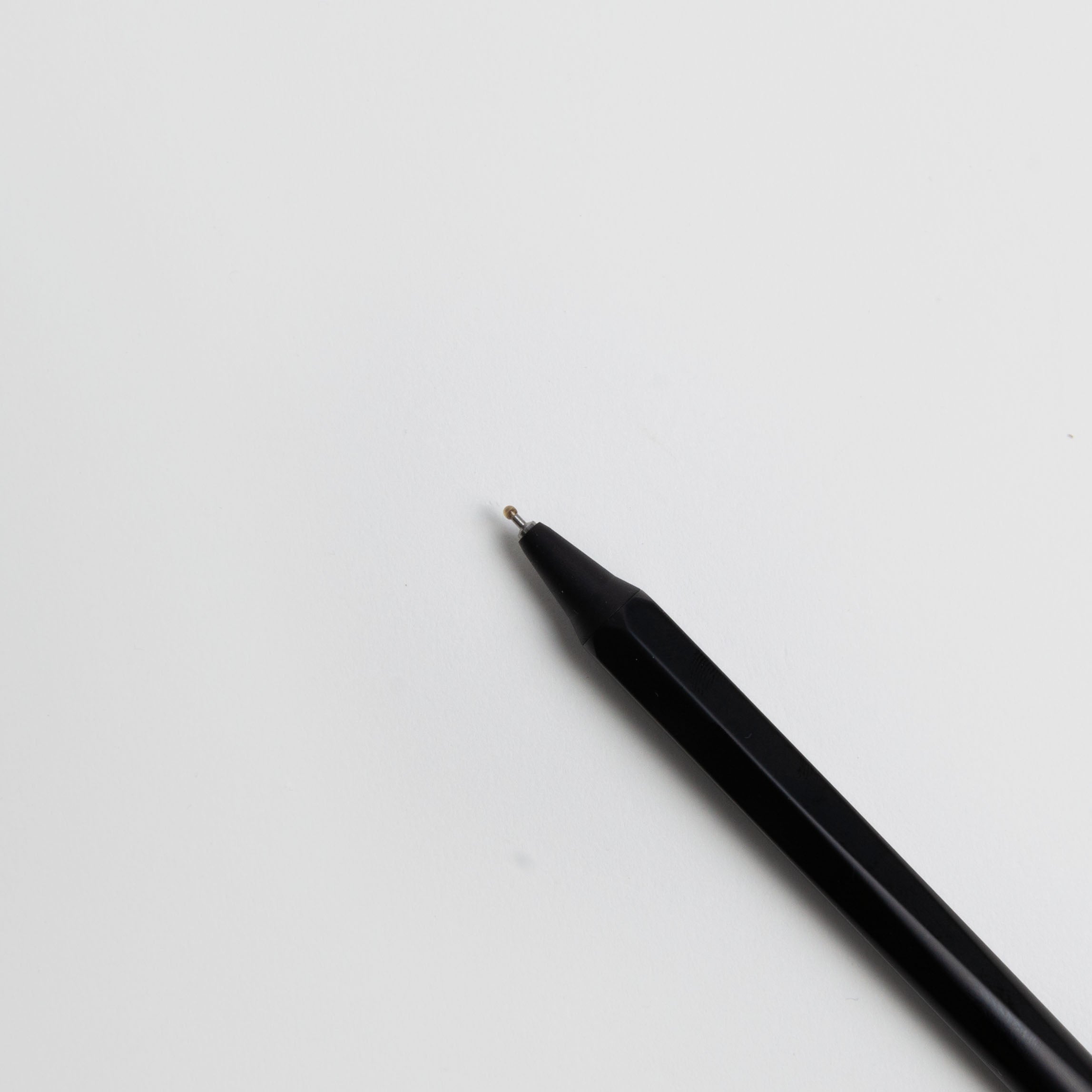 Ein schwarzer OHTO GS02 Gelschreiber - japanischer Gelstift von Marks Europe mit einer spitzen Spitze wird diagonal auf eine schlichte weiße Fläche gesetzt, die Spitze zeigt nach oben links. Dieser schlanke Gelstift ist nachfüllbar für längeren Gebrauch.