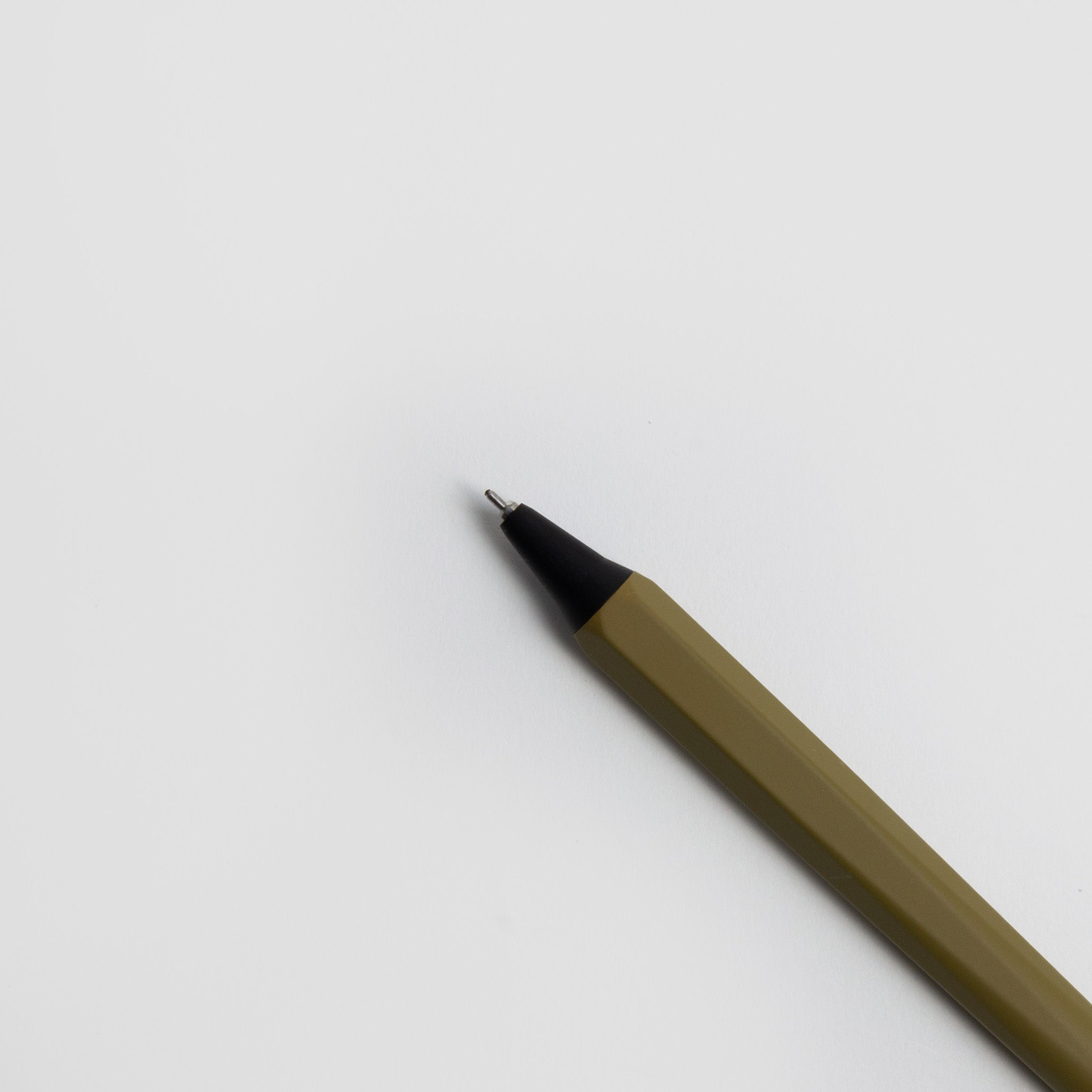 Eine Nahaufnahme eines gelben OHTO GS02 Gelschreibers - japanischer Gelstift von Marks Europe mit schwarzer Spitze liegt diagonal auf einer weißen Fläche, die sich von rechts unten bis zur Mitte erstreckt. Dieser schlanke Gelschreiber ist nachfüllbar für den Dauereinsatz.