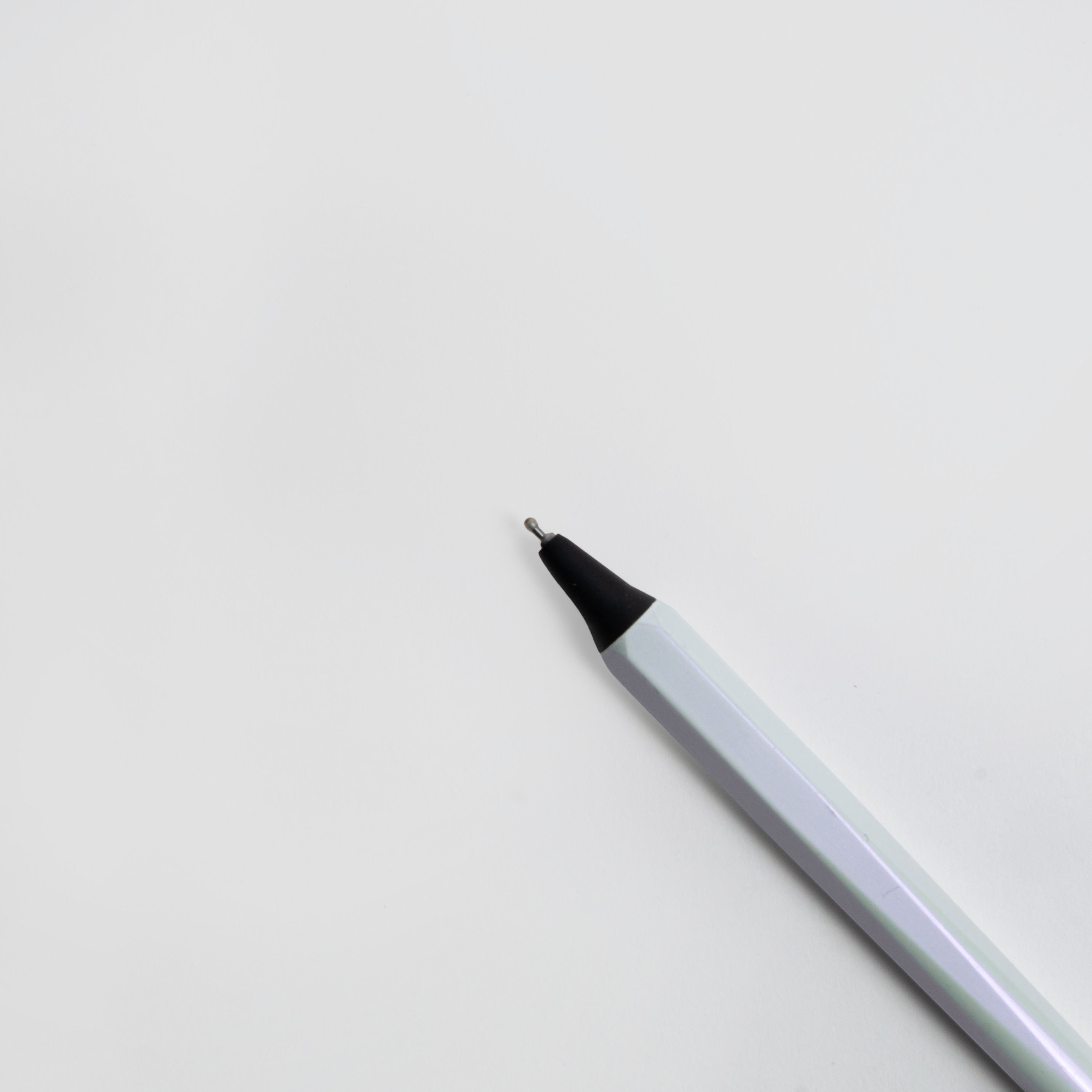 Eine Nahaufnahme des OHTO GS02 Gelschreibers - ein japanischer Gelstift von Marks Europe mit weißem Gehäuse und schwarzer Spitze, diagonal auf weißem Hintergrund platziert.
