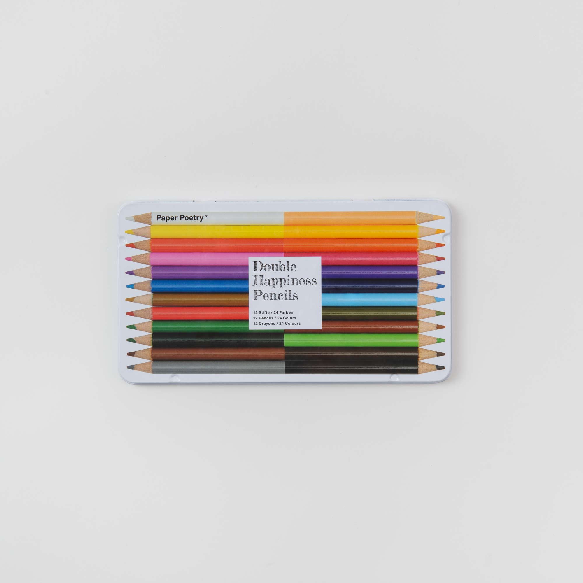 Das 2-in-1-Buntstifte im Etui von Paper Poetry ist ein Set mit zwölf leuchtenden Farben und umfasst Bleistifte mit Doppelspitze in einem eleganten Metalletui mit der Aufschrift „Double Happiness Pencils“, die übersichtlich angeordnet sind, um Farbtöne wie Rot, Blau, Grün und Orange zur Geltung zu bringen.