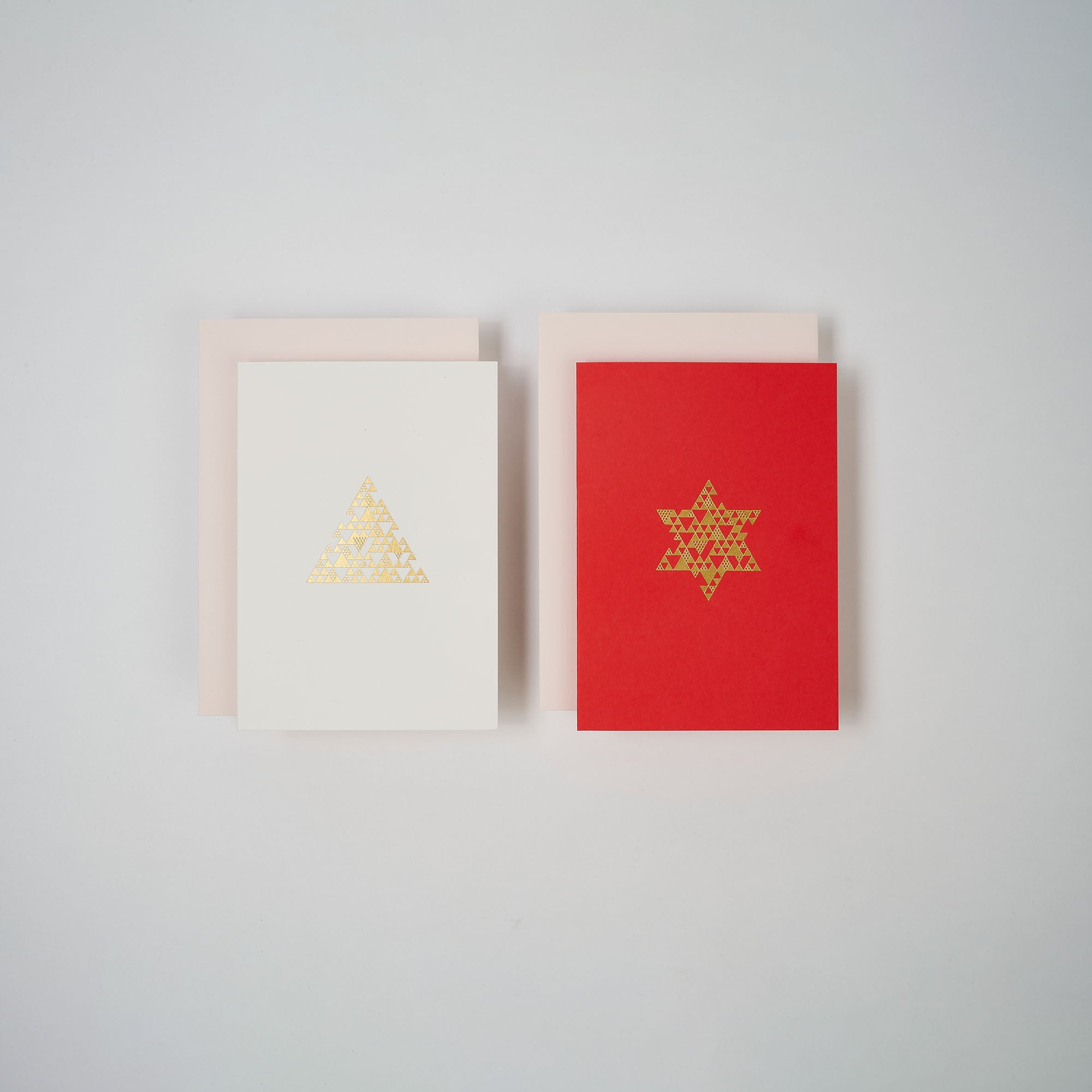 Zwei Weihnachtskarten aus dem paperlux.store 2er-Set Snow & Coral sind nebeneinander abgebildet, jeweils mit einem goldenen Motiv. Beide A6-Karten werden mit hellen Umschlägen geliefert.