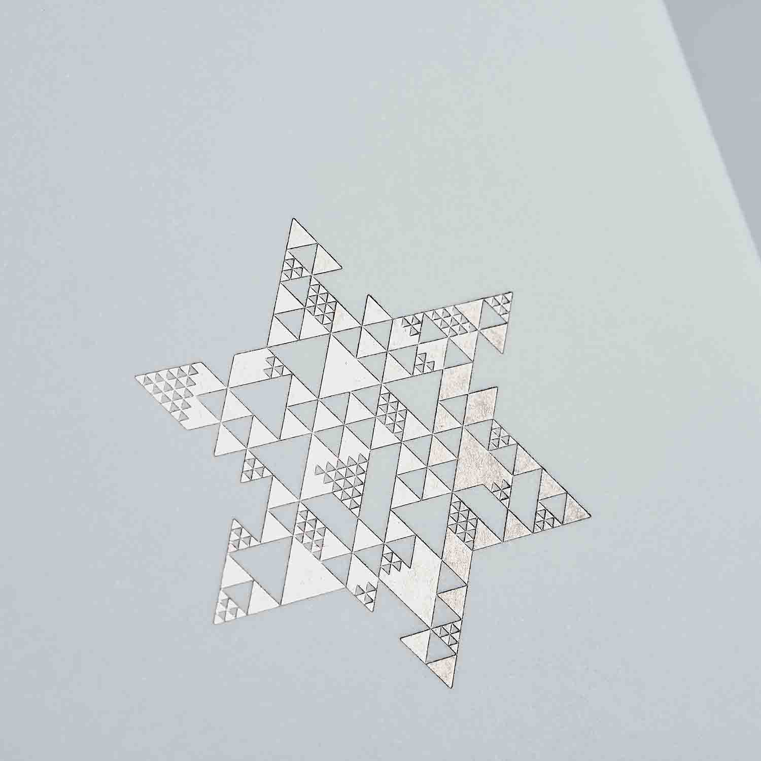 Das Weihnachtskarten 2er-Set Snow & Green von paperlux.store zeigt geometrische, ineinandergreifende Dreiecke und feine Liniendetails auf hellgrauem Hintergrund - ideal für festliche Grußkarten oder eine stilvolle Klappkarte.