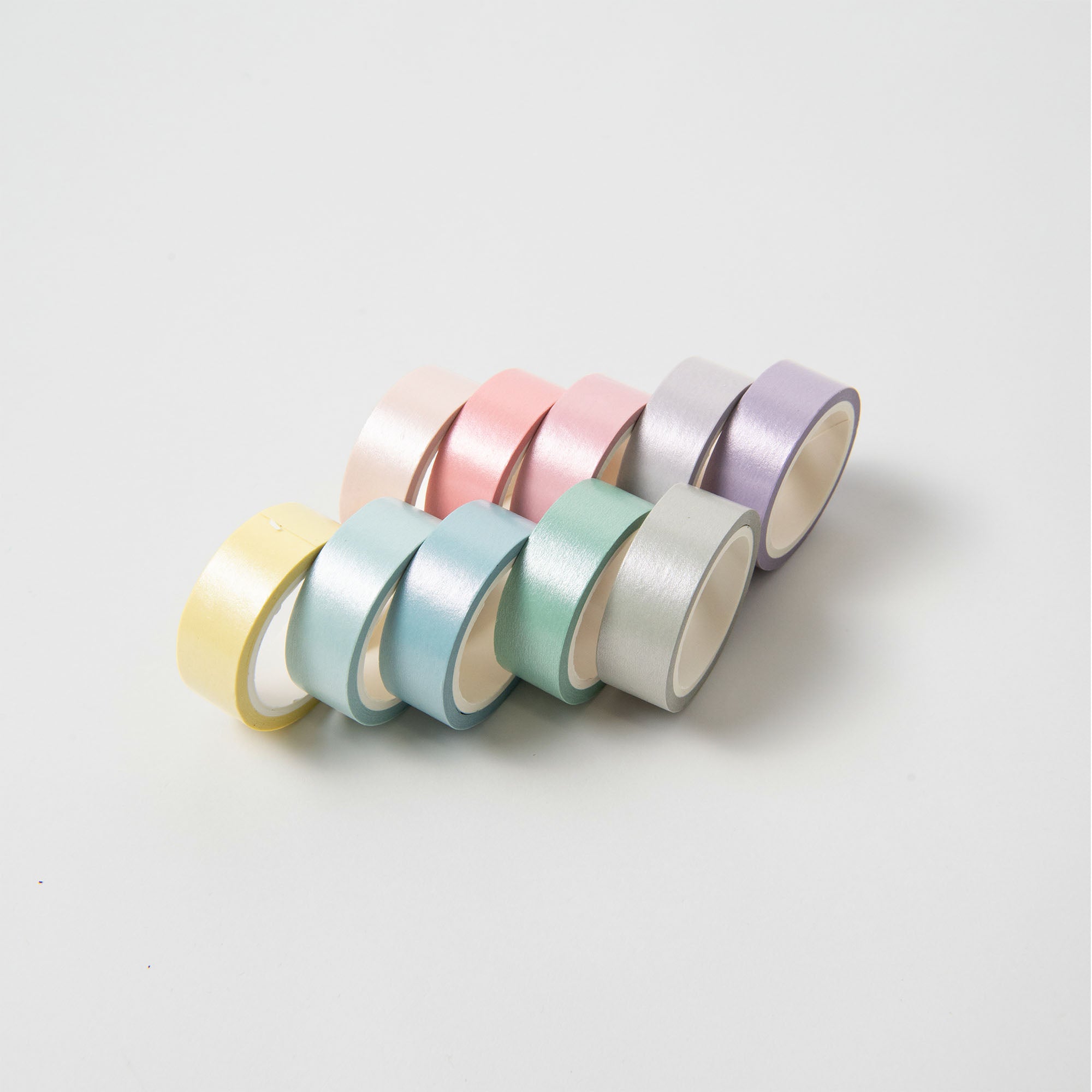 Das Pastell Tape Set von Paper Poetry besteht aus pastellfarbenen Washi-Tape-Rollen, die in zwei Reihen auf weißem Hintergrund angeordnet sind. Das Set eignet sich perfekt zum Basteln und zum Verzieren von Geschenken. Es enthält hellgelbe, rosa, blaugrüne, hellgrüne und lavendelfarbene Bänder mit einer dezenten matten Textur.
