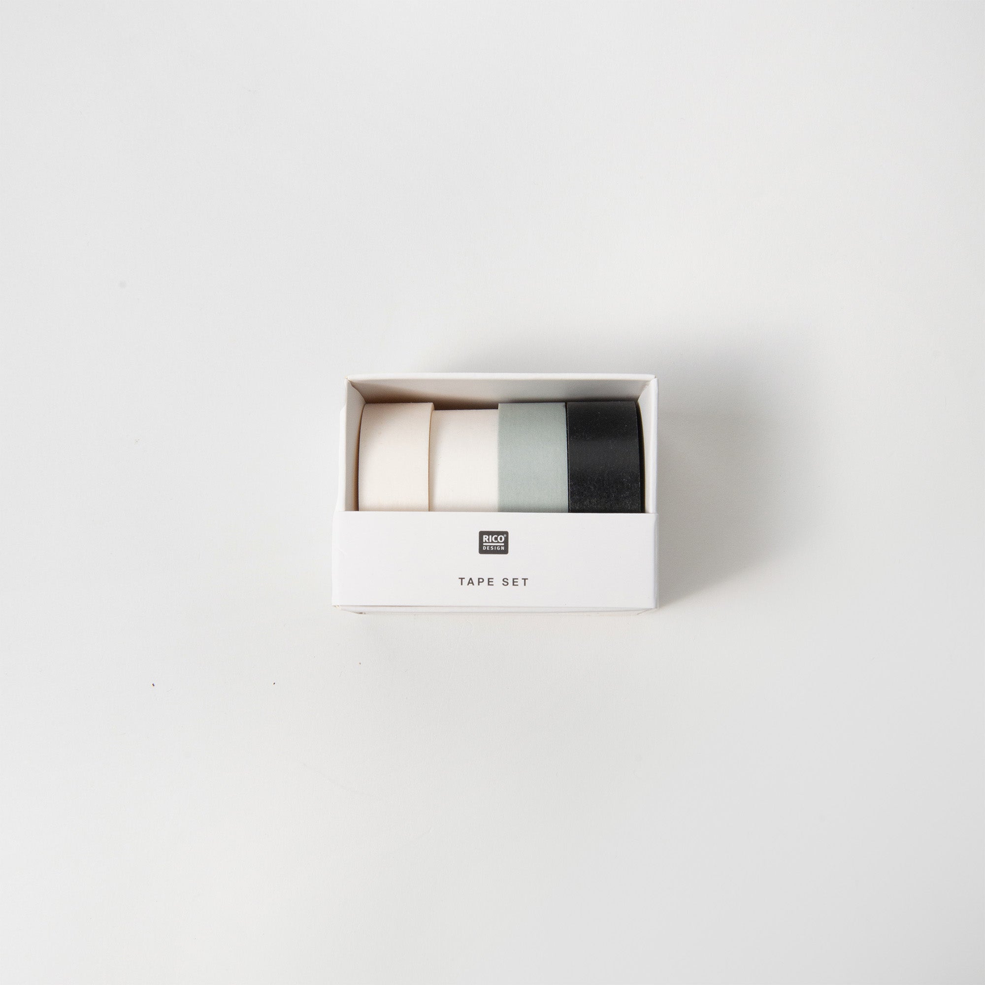 Das Paper Poetry Set schwarz/weiss Tapes enthält drei Kleberollen in Creme, Hellgrün und Schwarz, präsentiert in einer weißen „TAPE SET“-Box. Perfekt zum Basteln oder Verpacken, ideal, um Geschenken eine kreative Note zu verleihen.