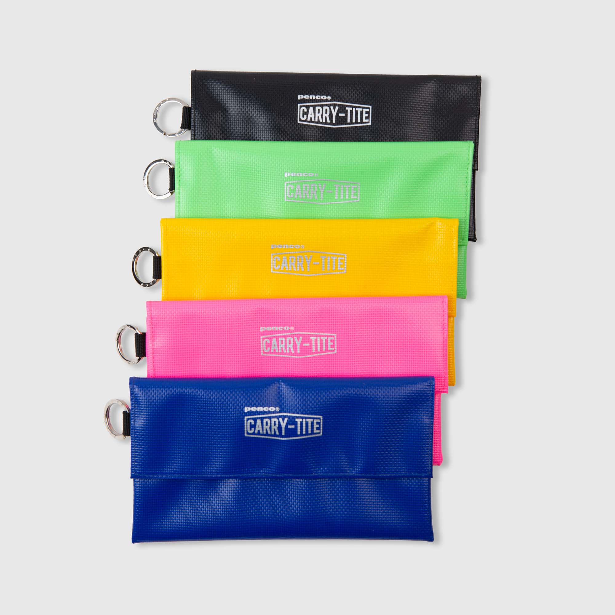 Fünf rechteckige „Penco Carry Tite Tarp“-Stifteetuis in den Farben Schwarz, Grün, Gelb, Rosa und Blau sind übereinander gestapelt. Jedes Etui von Penco besteht aus wasserfestem PVC-Planenstoff und verfügt über einen Metallring sowie das Etikett „Penco Carry Tite Mäppchen“ auf der Vorderseite, alles vor einem schlichten grauen Hintergrund.