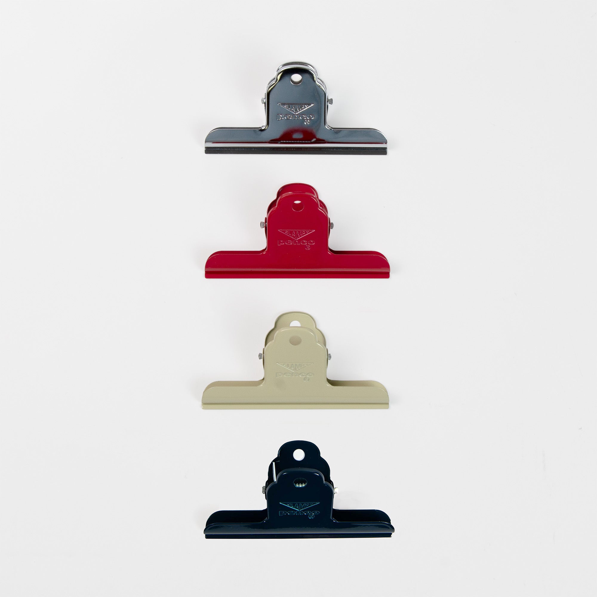 Vier Clampy Clip M Binder Clips von Penco in Silber, Rot, Beige und Dunkelblau sind vertikal vor einem weißen Hintergrund angeordnet.