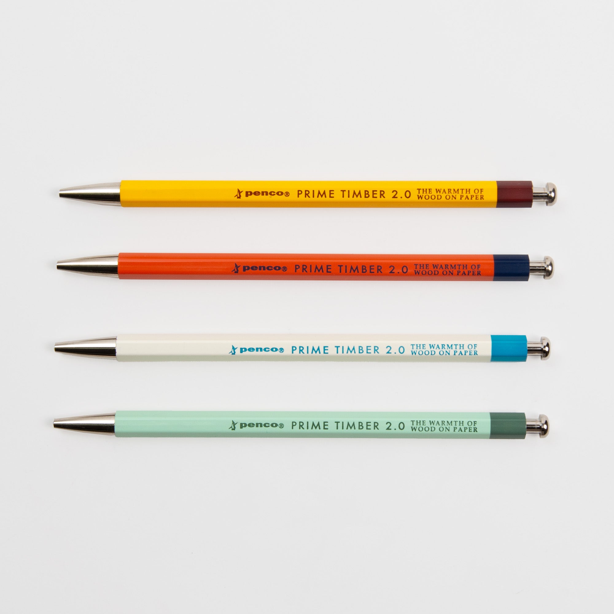 Vier Penco Prime Timber Druckbleistifte in Rot, Orange, Weiß und Hellgrün, jeweils mit der Aufschrift PRIME TIMBER 2.0" und THE WARMTH OF WOOD ON PAPER", zeigen japanisches Design mit einer glatten 2 mm Mine auf weißem Hintergrund.