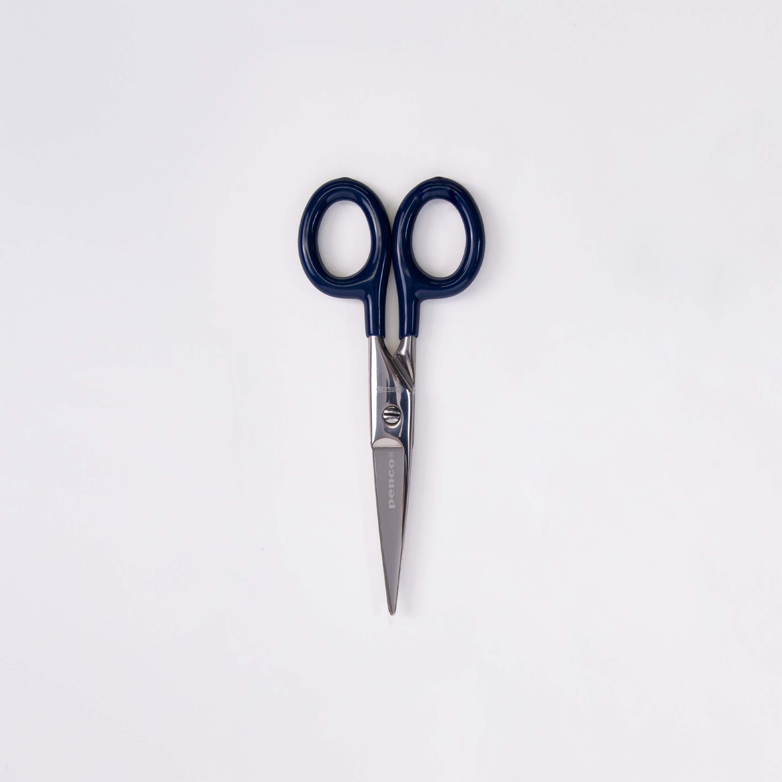 Die Penco Edelstahl Schere - S mit glänzenden Klingen und dunkelblauen Griffen liegt mit geschlossenen Klingen und nach oben gerichteten Griffen auf einer schlichten weißen Oberfläche.