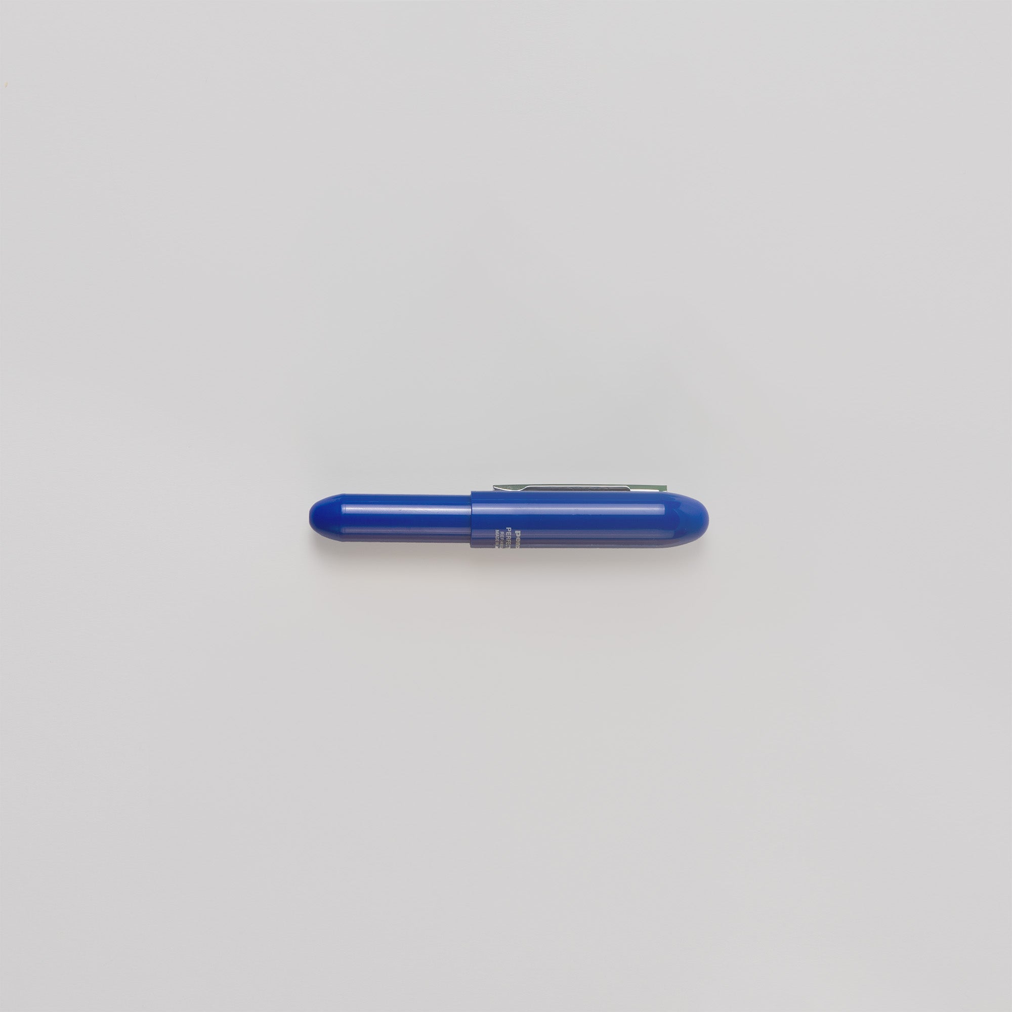 Ein blauer Penco Bullet Kugelschreiber mit feiner Spitze und silbernem Clip liegt horizontal auf einem schlichten weißen Hintergrund.
