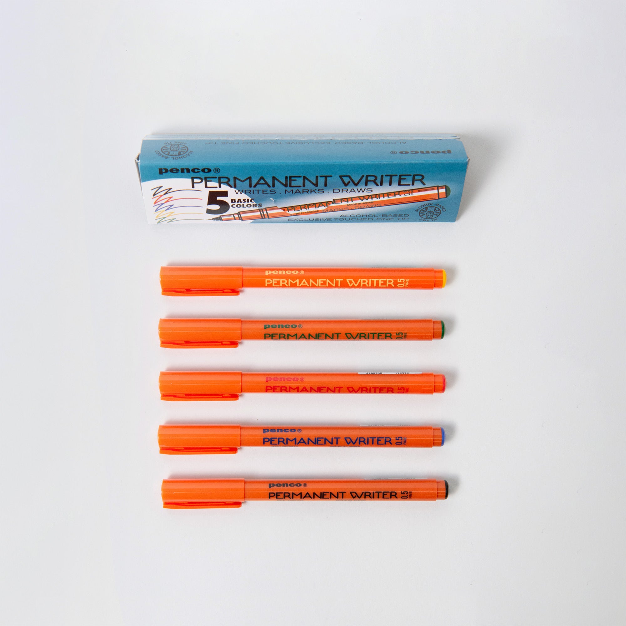Fünf orangefarbene Penco Permanent Writer-Marker mit 0,5-mm-Spitzen sind unter einer blauen „Penco Permanent Writer“-Box aufgereiht. Diese Marker mit alkoholbasierter Tinte und orangefarbener Kappe und dem Markennamen auf dem Schaft eignen sich perfekt zum Schreiben, Markieren und Zeichnen und regen die Kreativität an.