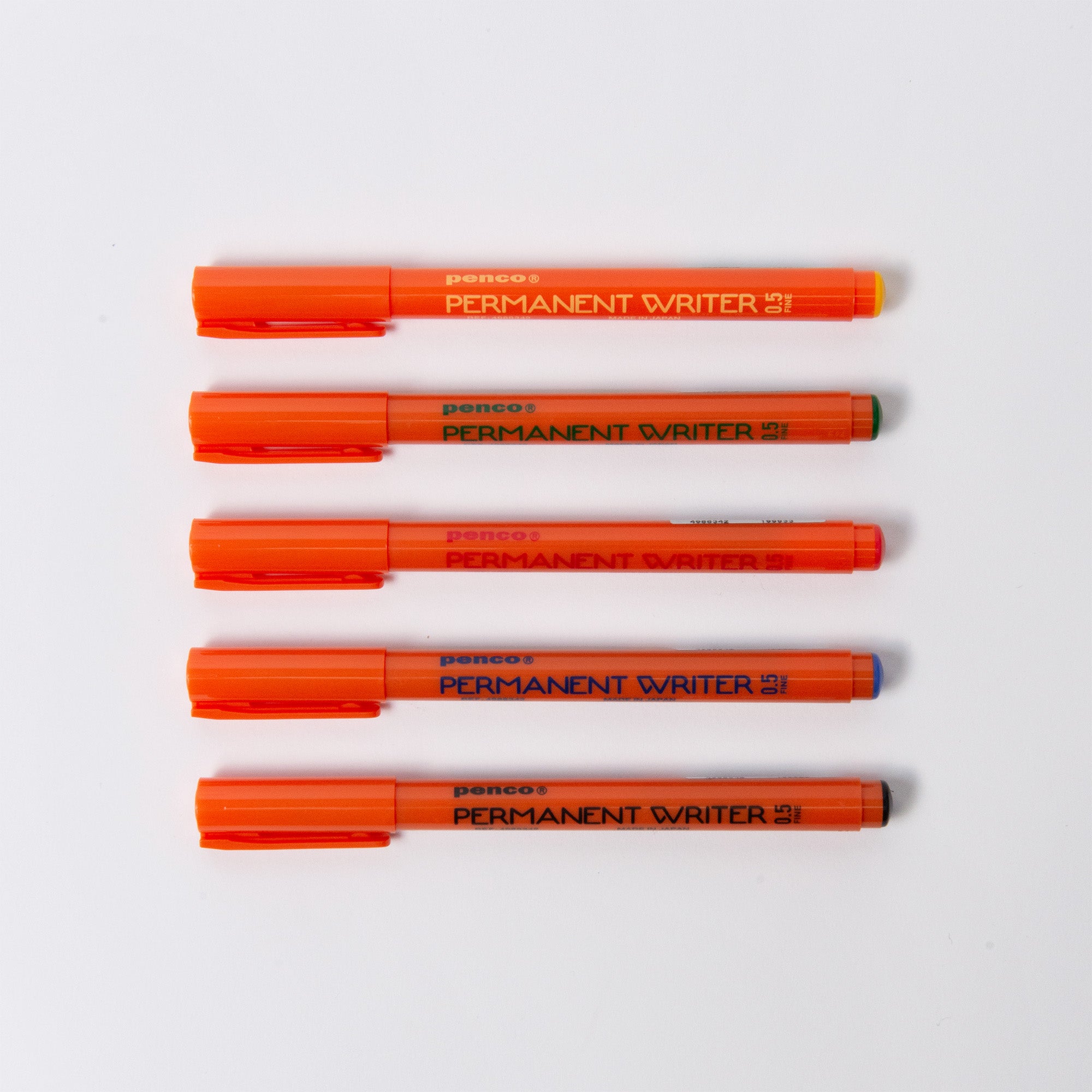 Fünf orangefarbene Penco Permanent Writer-Stifte mit Kappen sind horizontal auf einer weißen Oberfläche ausgerichtet. Jeder Stift hat eine präzise 0,5-mm-Spitze, die sich ideal für kreative Projekte eignet und in dieser Anordnung schlankes Design und die Leistungsfähigkeit der alkoholbasierten Tinte zeigt.