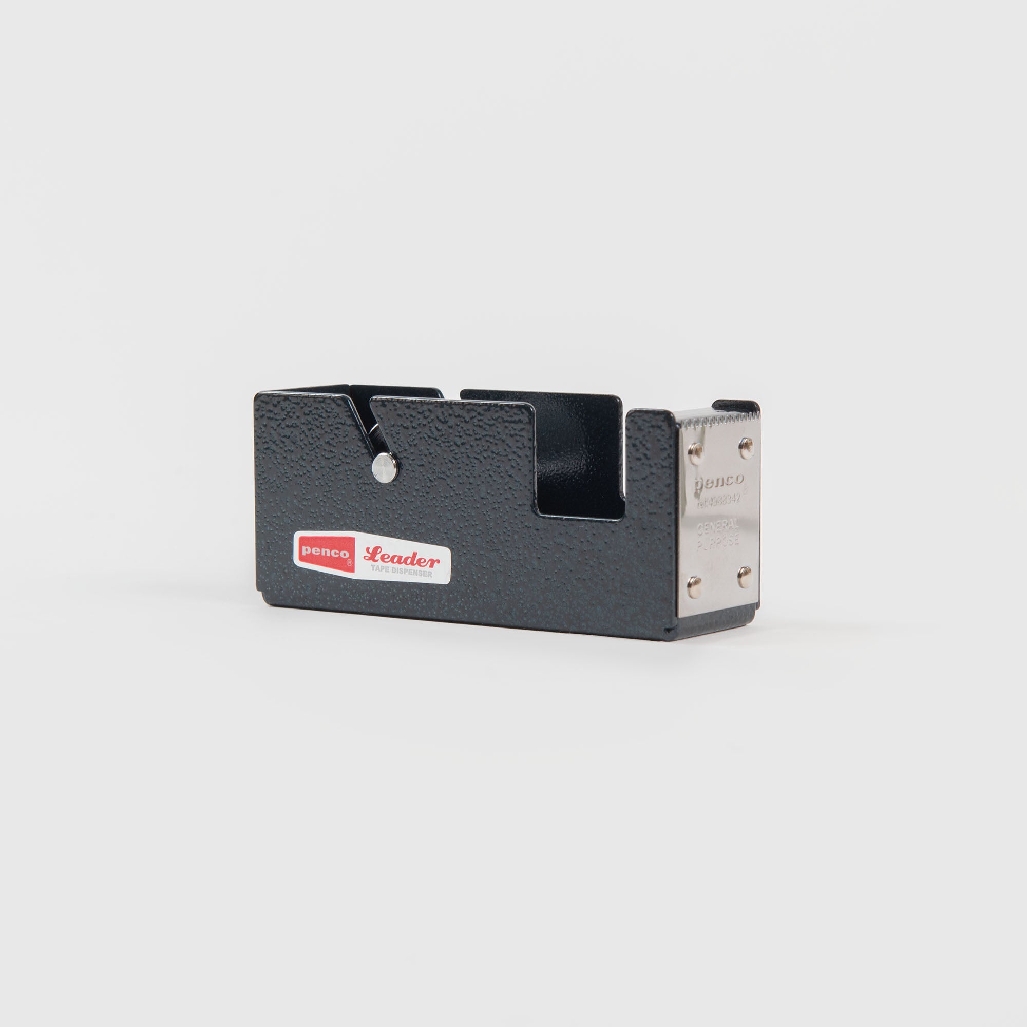 Der Klebebandabroller S - Klebebandabroller von Penco zeichnet sich durch ein schwarz-silbernes Metalldesign mit strukturierter Oberfläche und dem rot-weißen Penco-Etikett aus, das sich perfekt zum Verpacken von Geschenken eignet und auf einem schlichten weißen Hintergrund abgebildet ist.