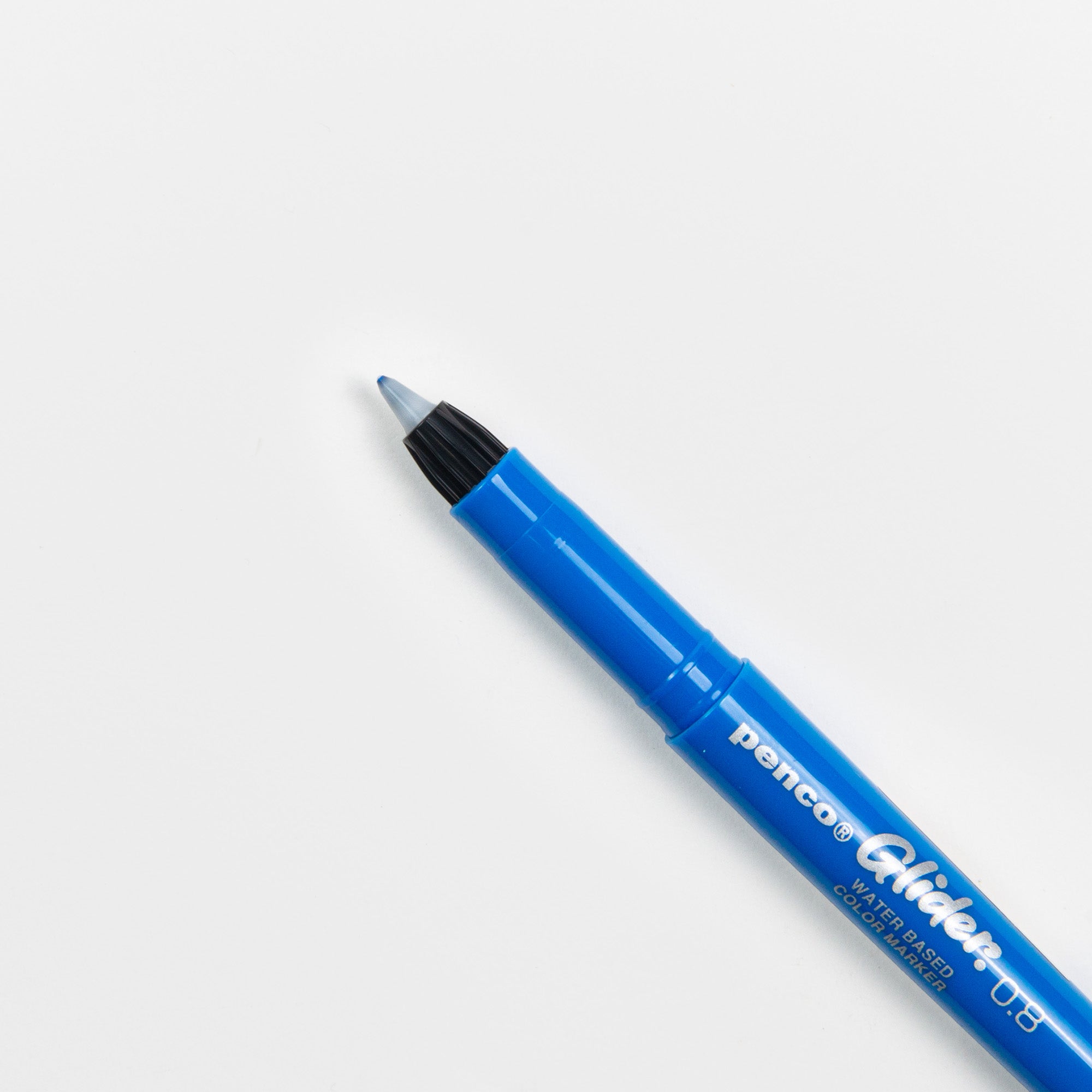 Ein blauer Penco Glider Colour Pen mit wasserbasierter Tinte und sichtbarer Spitze ruht auf einem schlichten weißen Hintergrund - ideal für alle, die ein Retro-Stift-Erlebnis suchen.
