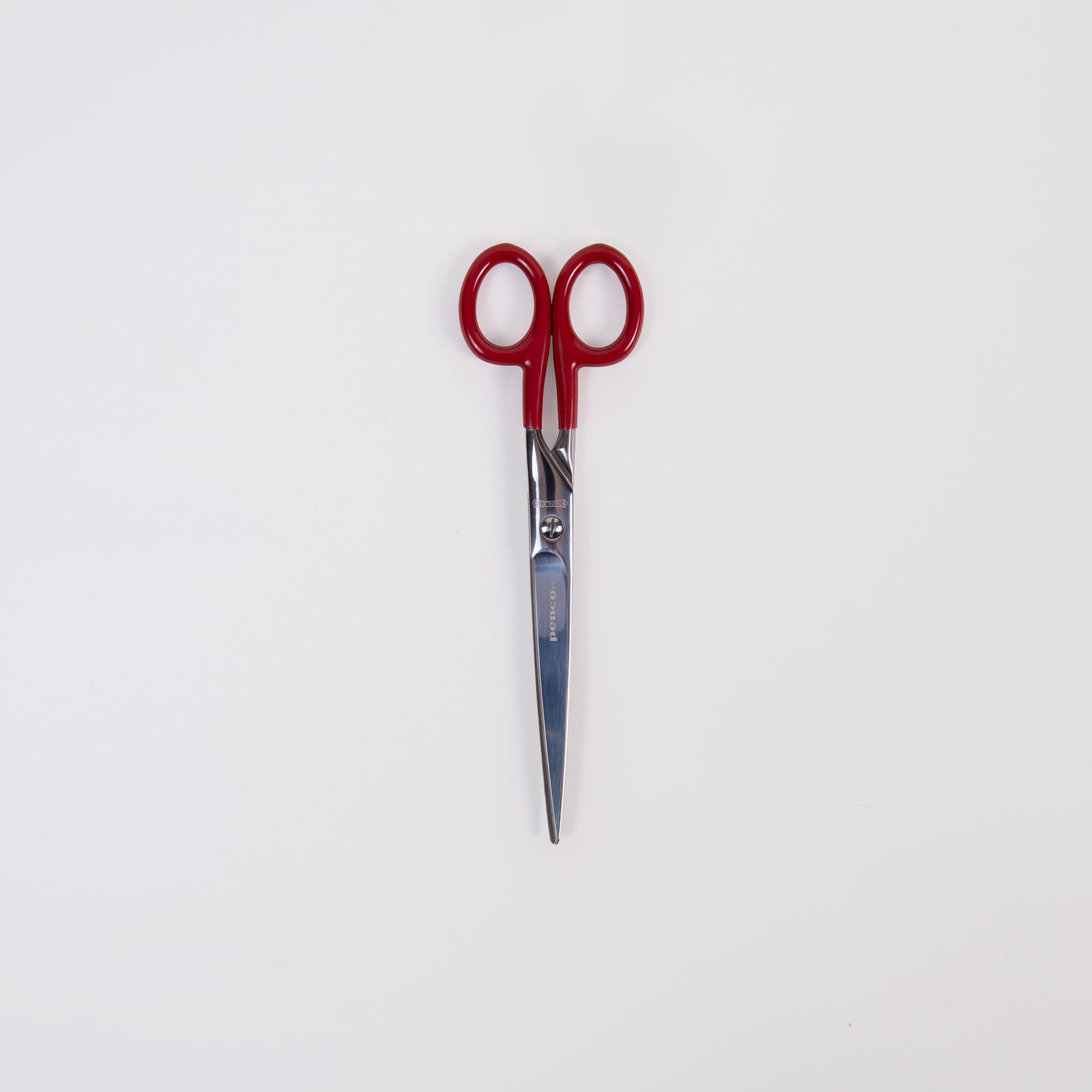 Die Penco Edelstahl Schere - L verfügt über elegante silberne Edelstahlklingen und Griffe mit leuchtend rotem PVC-Finish vor einem schlichten weißen Hintergrund.